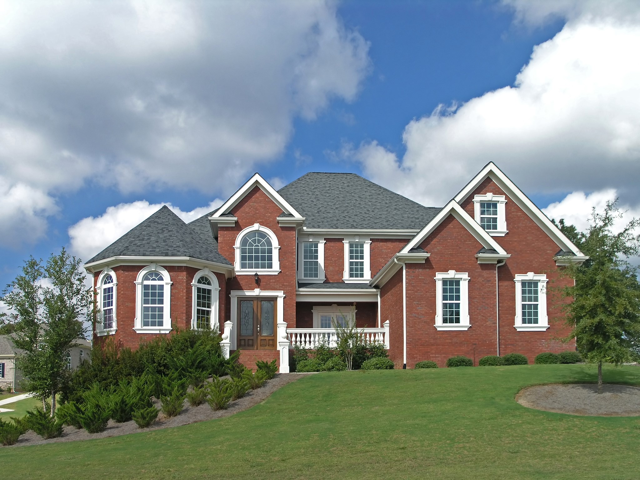 Red brick mansion with arched windows and dormers HD Wallpaper