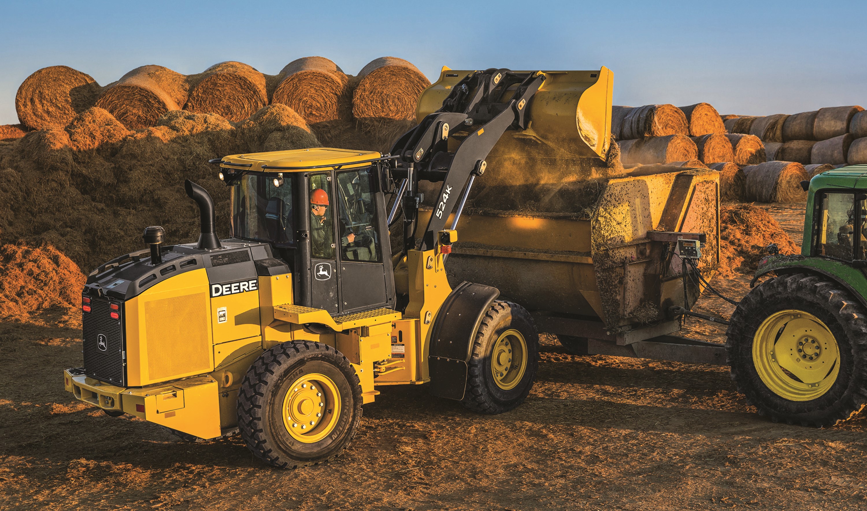 John Deere 524K Loader dumping hay bales HD Wallpaper