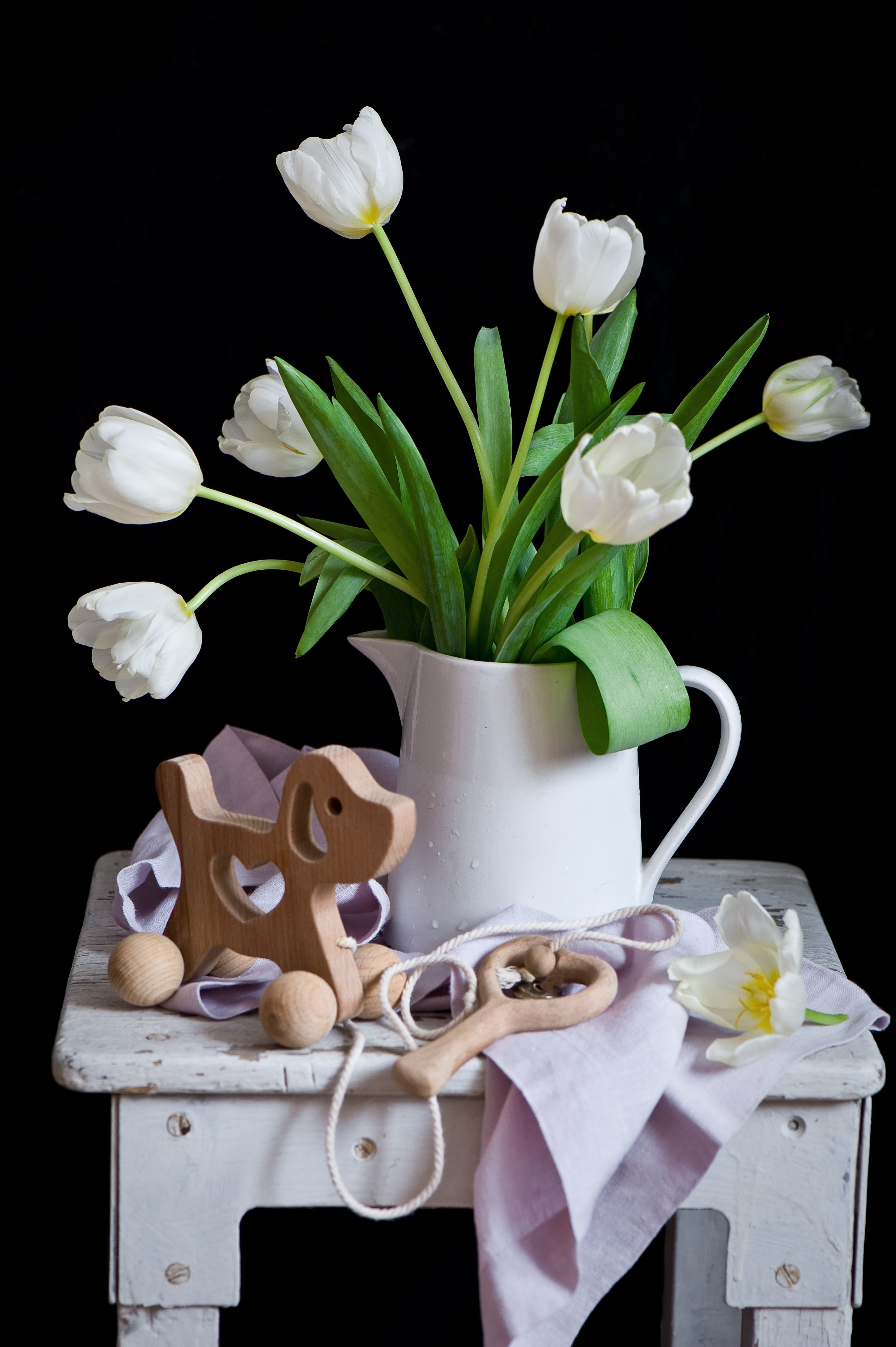 White tulips in a jug with wooden toys HD Phone Wallpaper