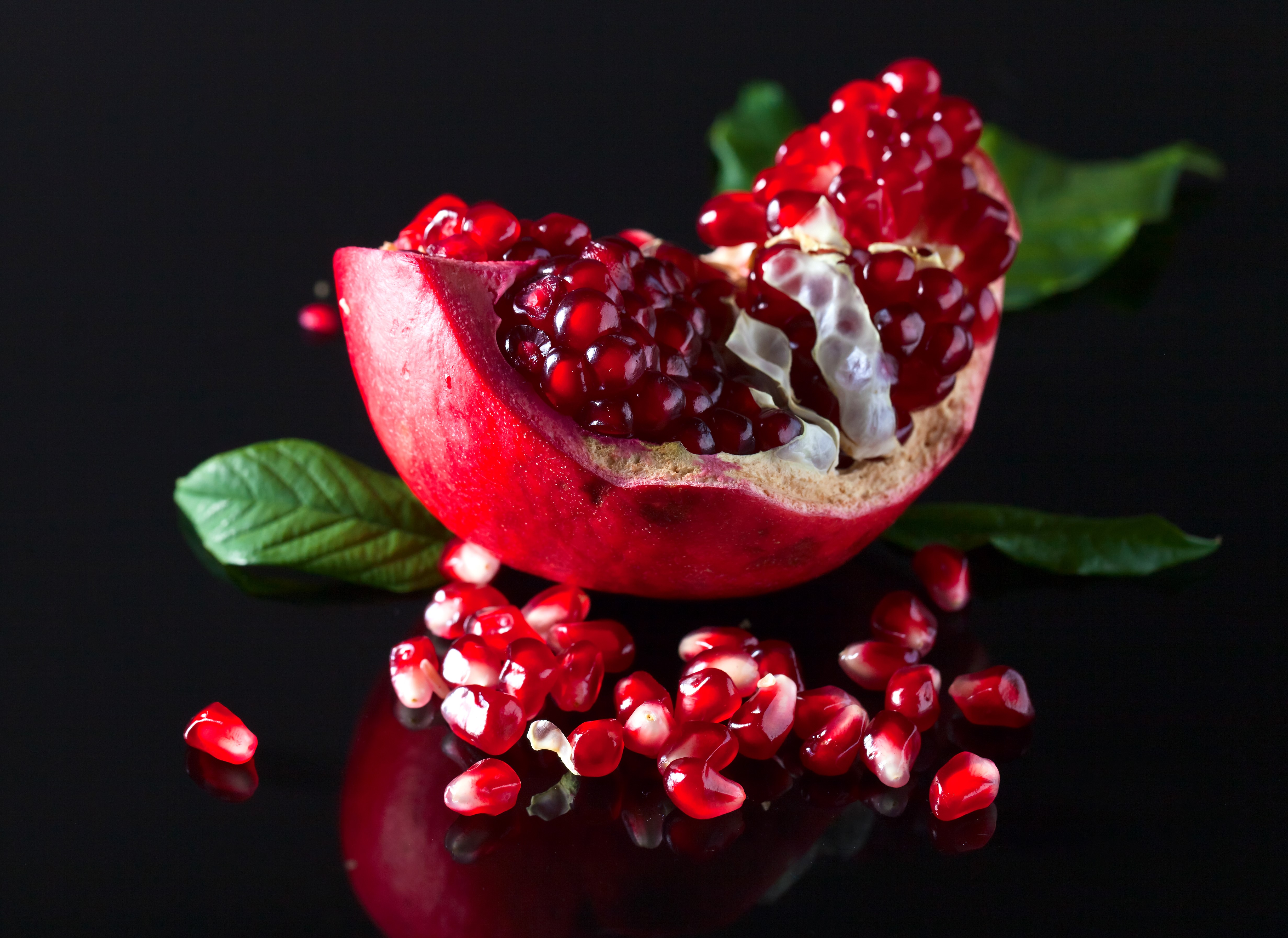 4K Pomegranate Slice with Seeds on Black Background HD Wallpaper