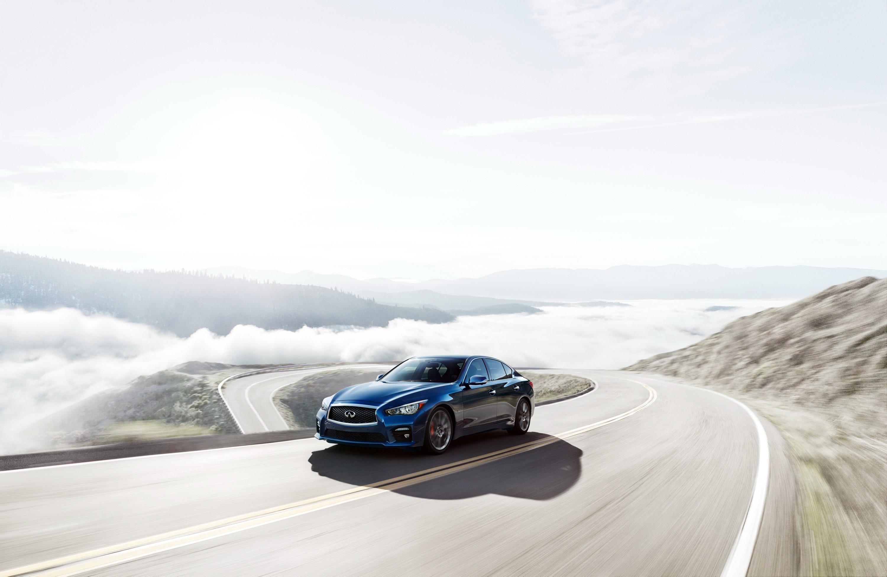 Blue Infiniti Q50S 3.0t driving on a mountain road HD Wallpaper
