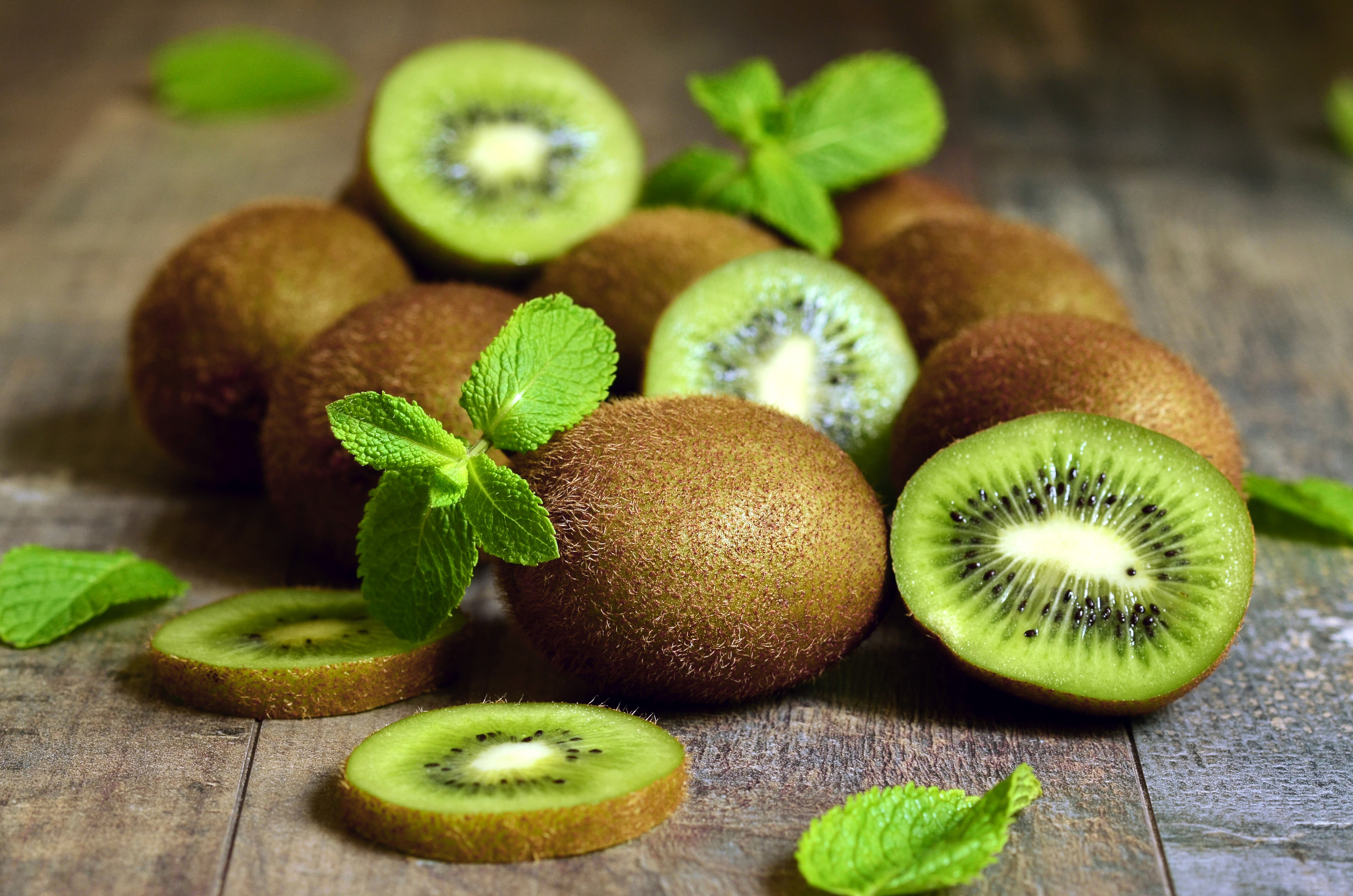 Kiwi fruits and mint leaves on wood HD Wallpaper