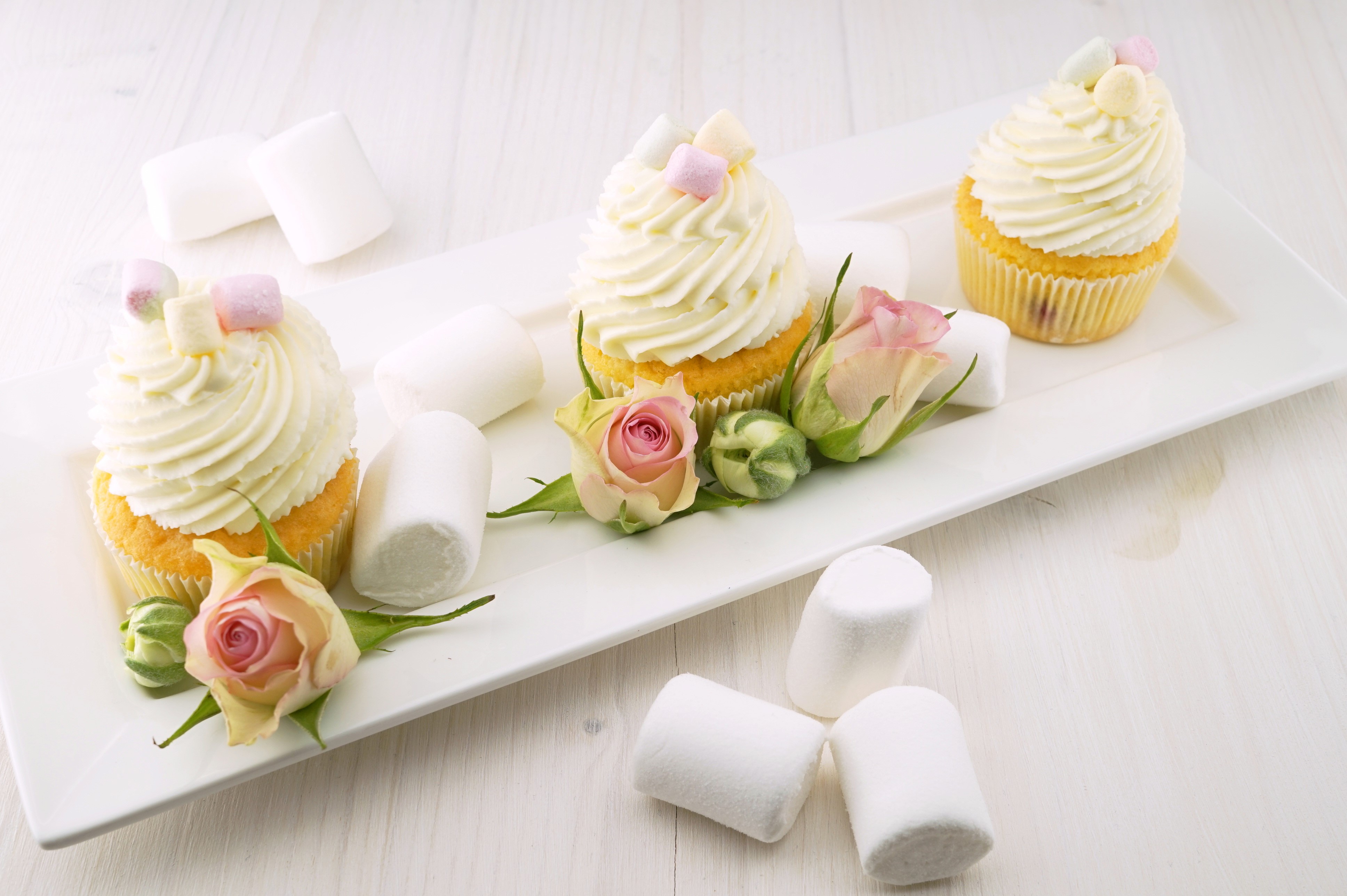 Three cupcakes with frosting, marshmallows, and roses HD Wallpaper