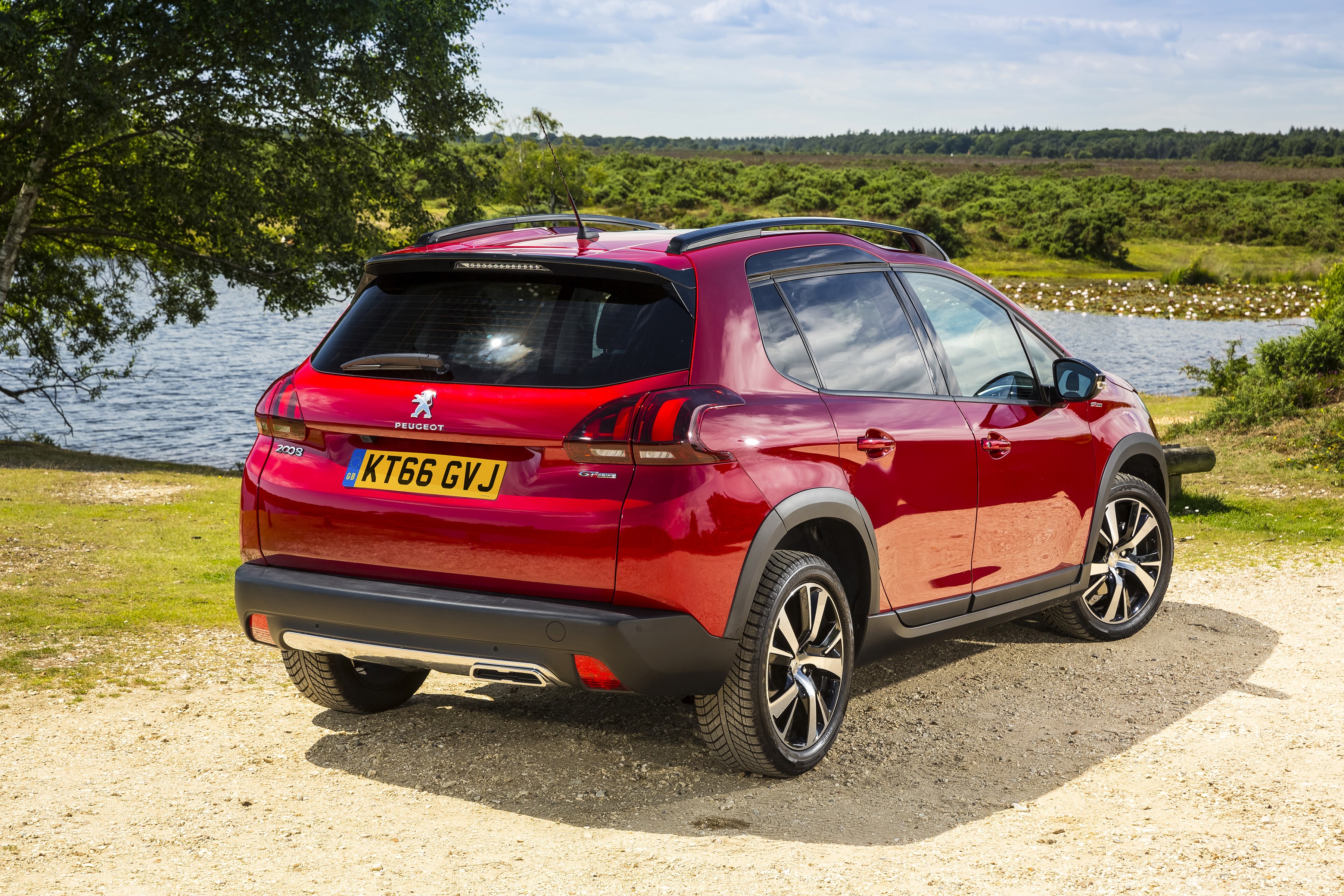 Red Peugeot 2008 GT Line parked by a lake HD Wallpaper