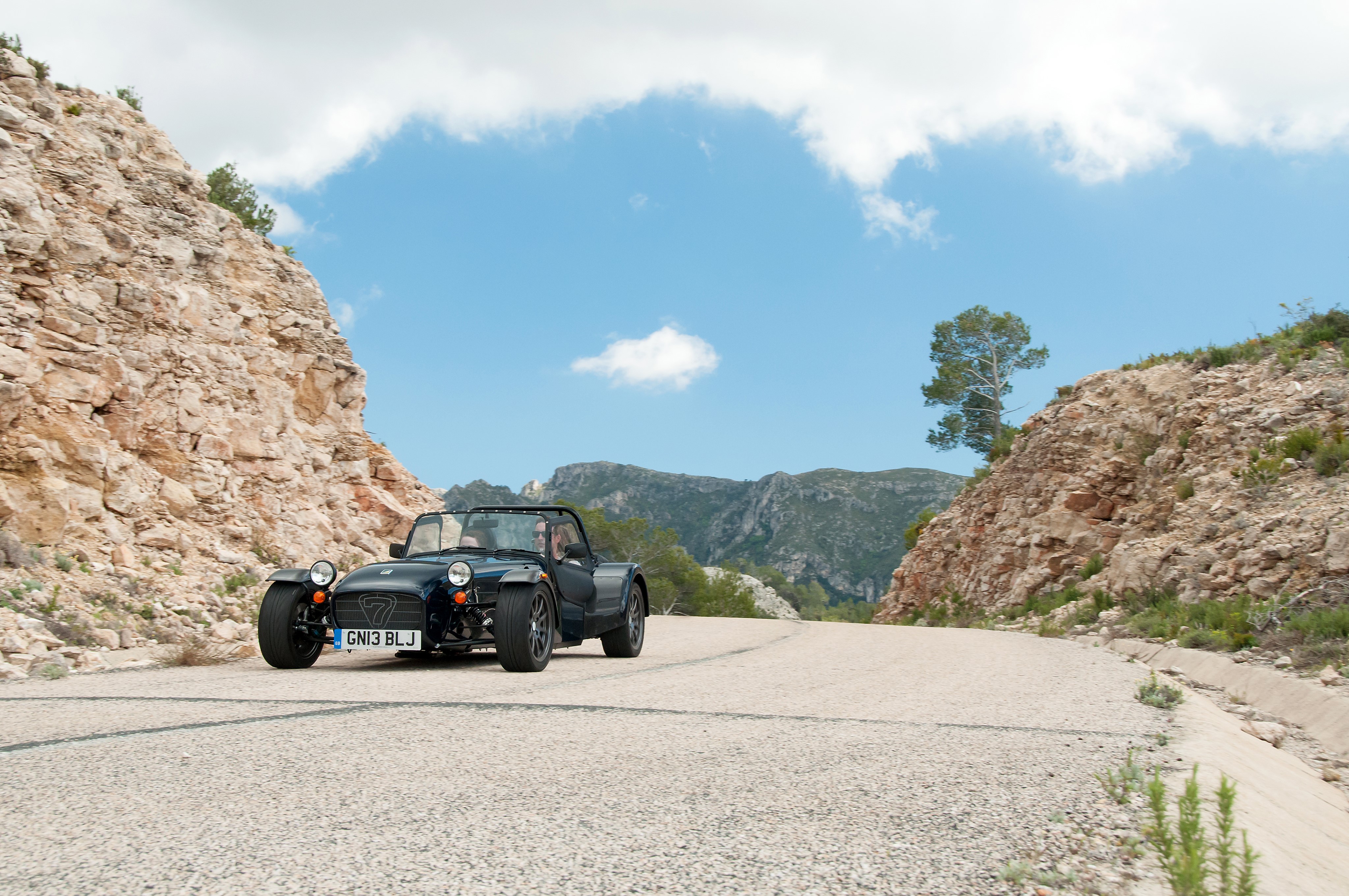 Caterham 7 driving on a mountain road HD Wallpaper