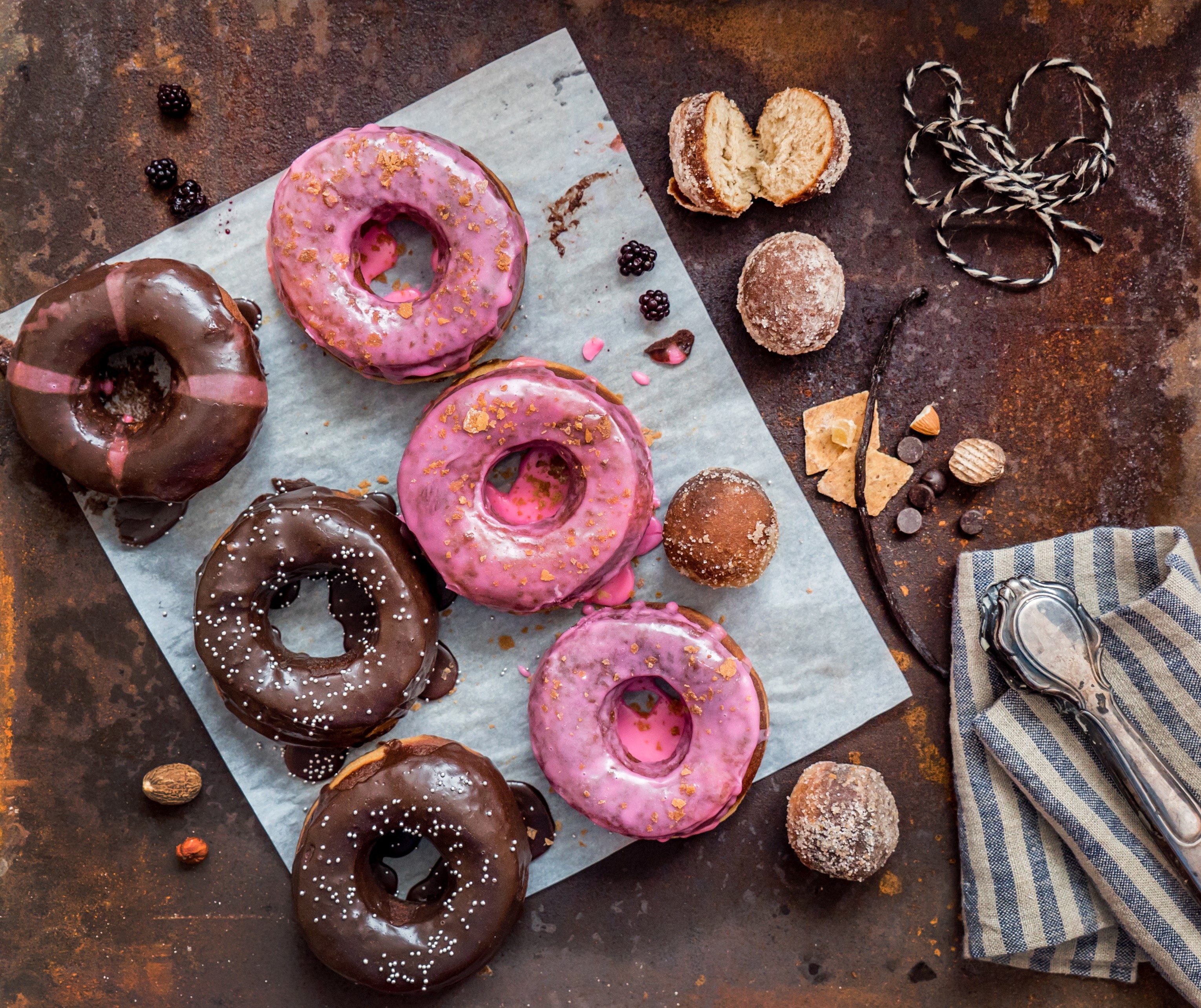 Assortment of donuts with chocolate and pink icing HD Wallpaper