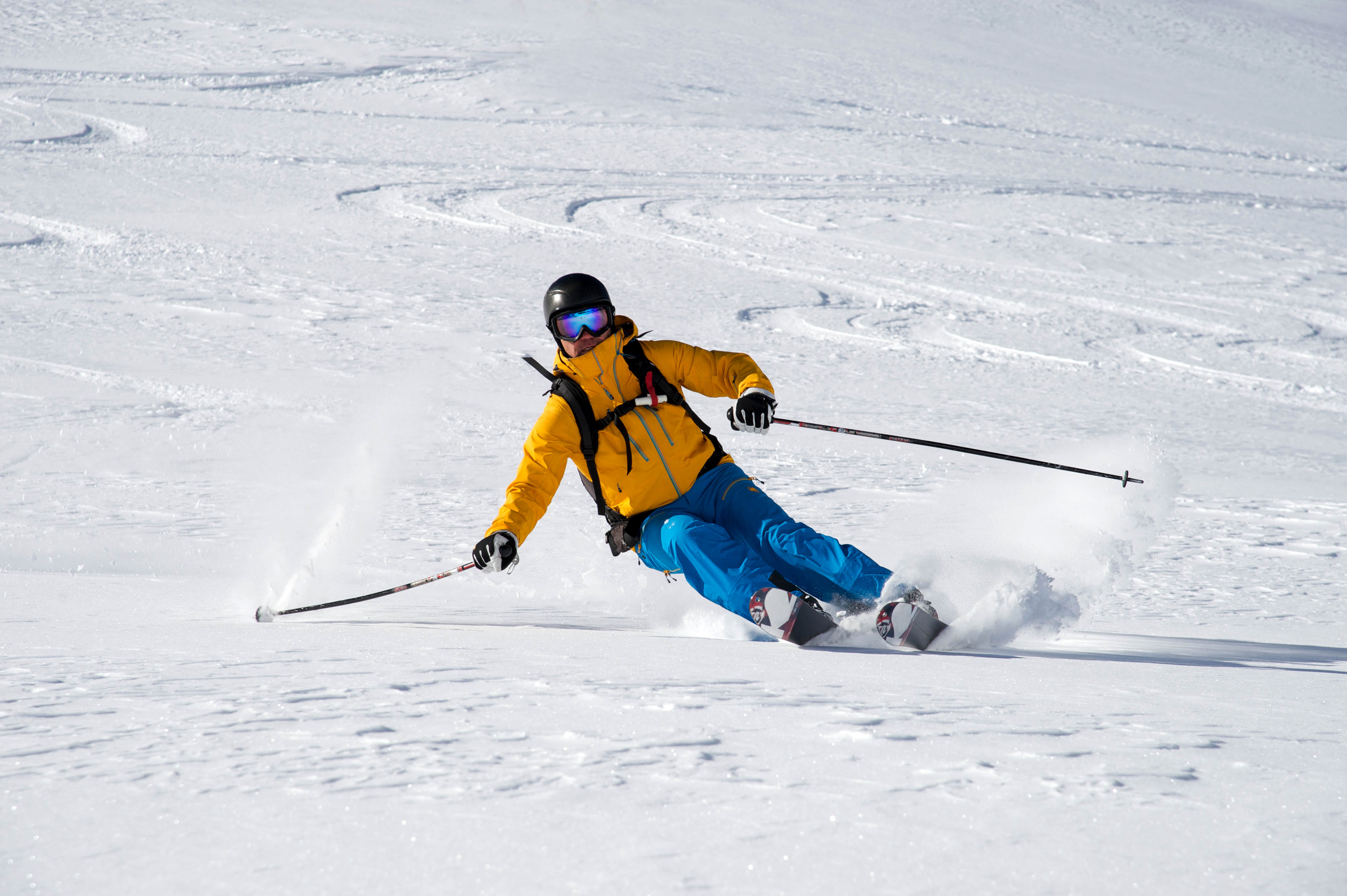 Man skiing down a snowy slope HD Wallpaper