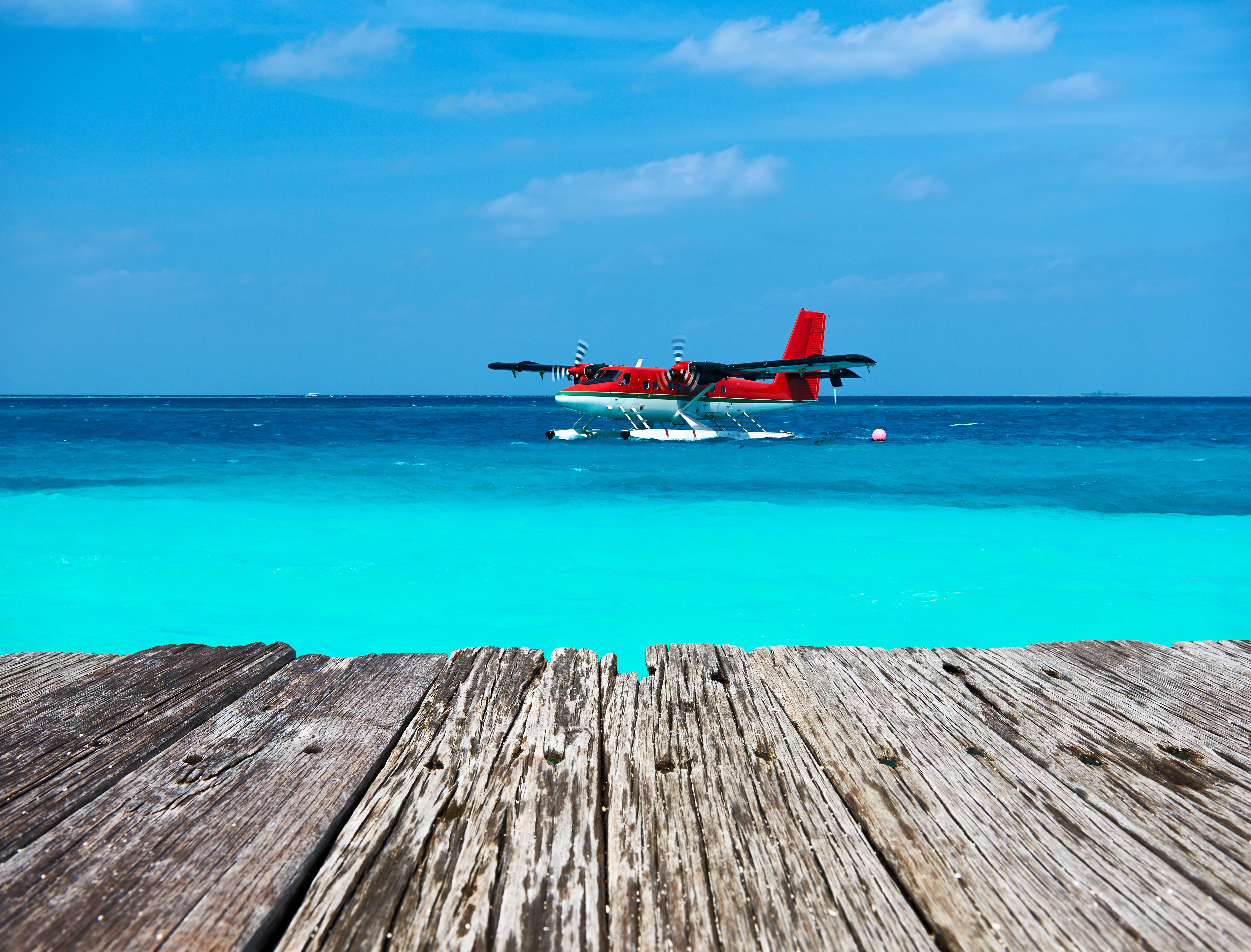 Seaplane on turquoise water with wooden planks HD Wallpaper