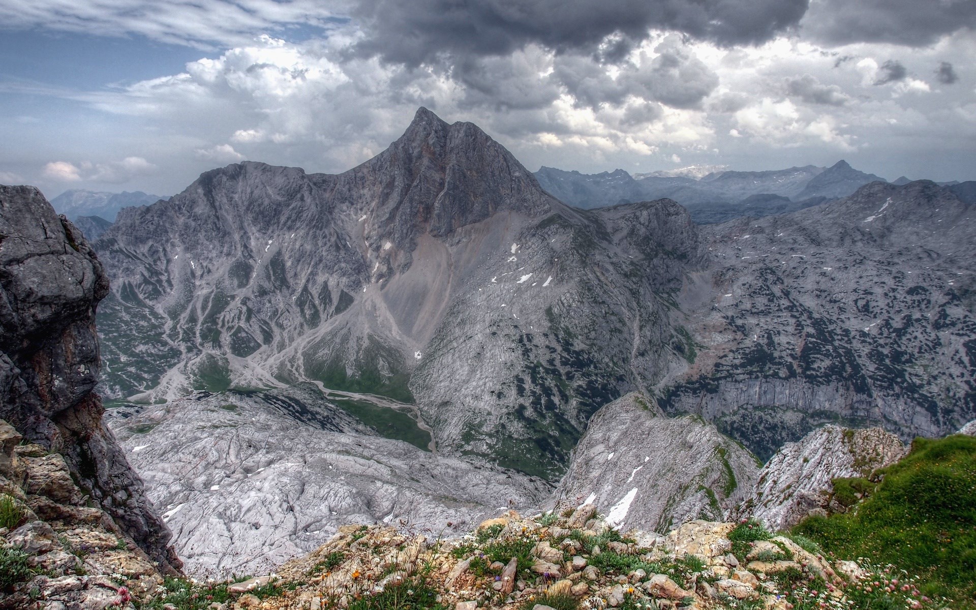 Jagged mountain range under a cloudy sky HD Wallpaper