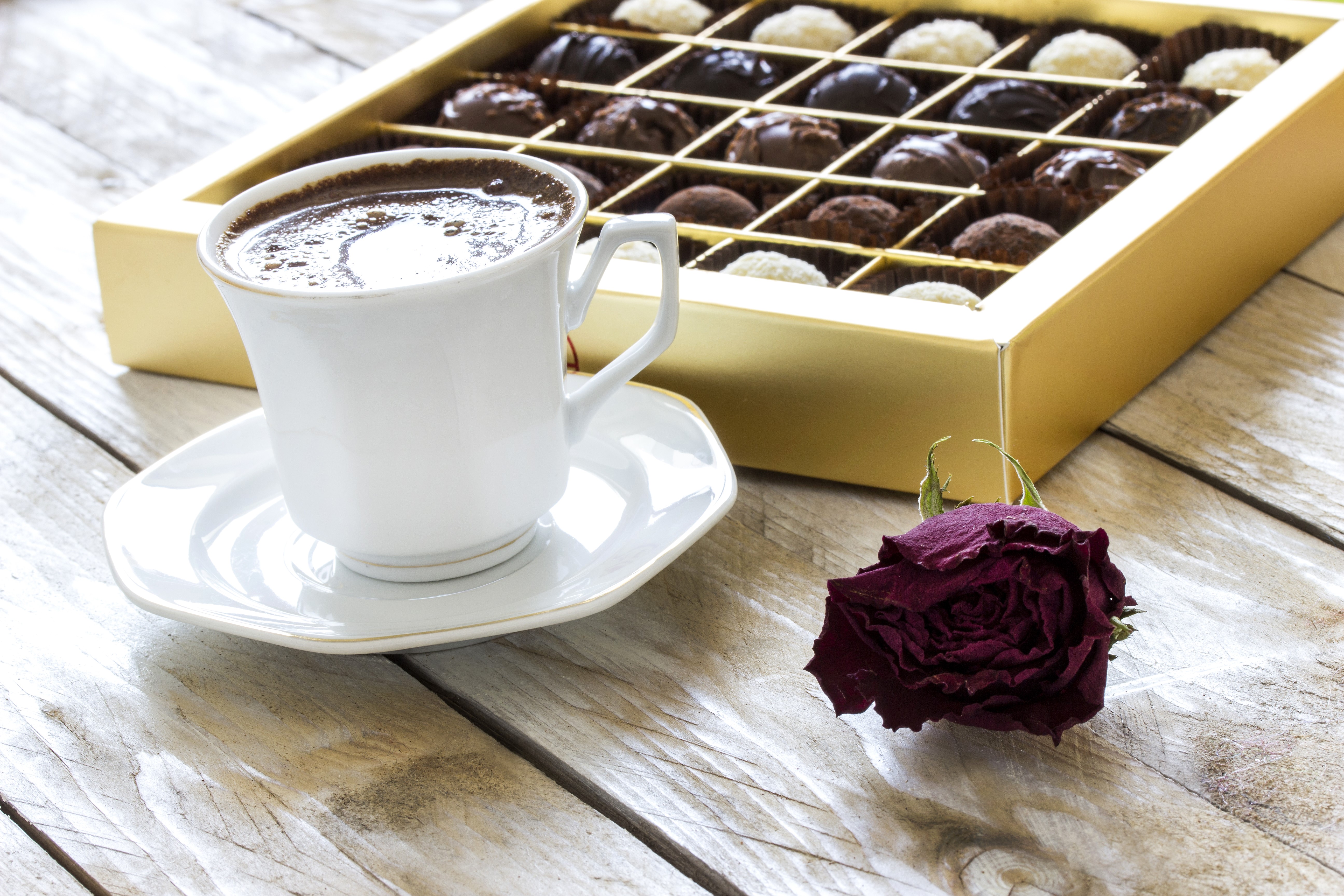Coffee cup, box of chocolates, and dried rose on wood HD Wallpaper