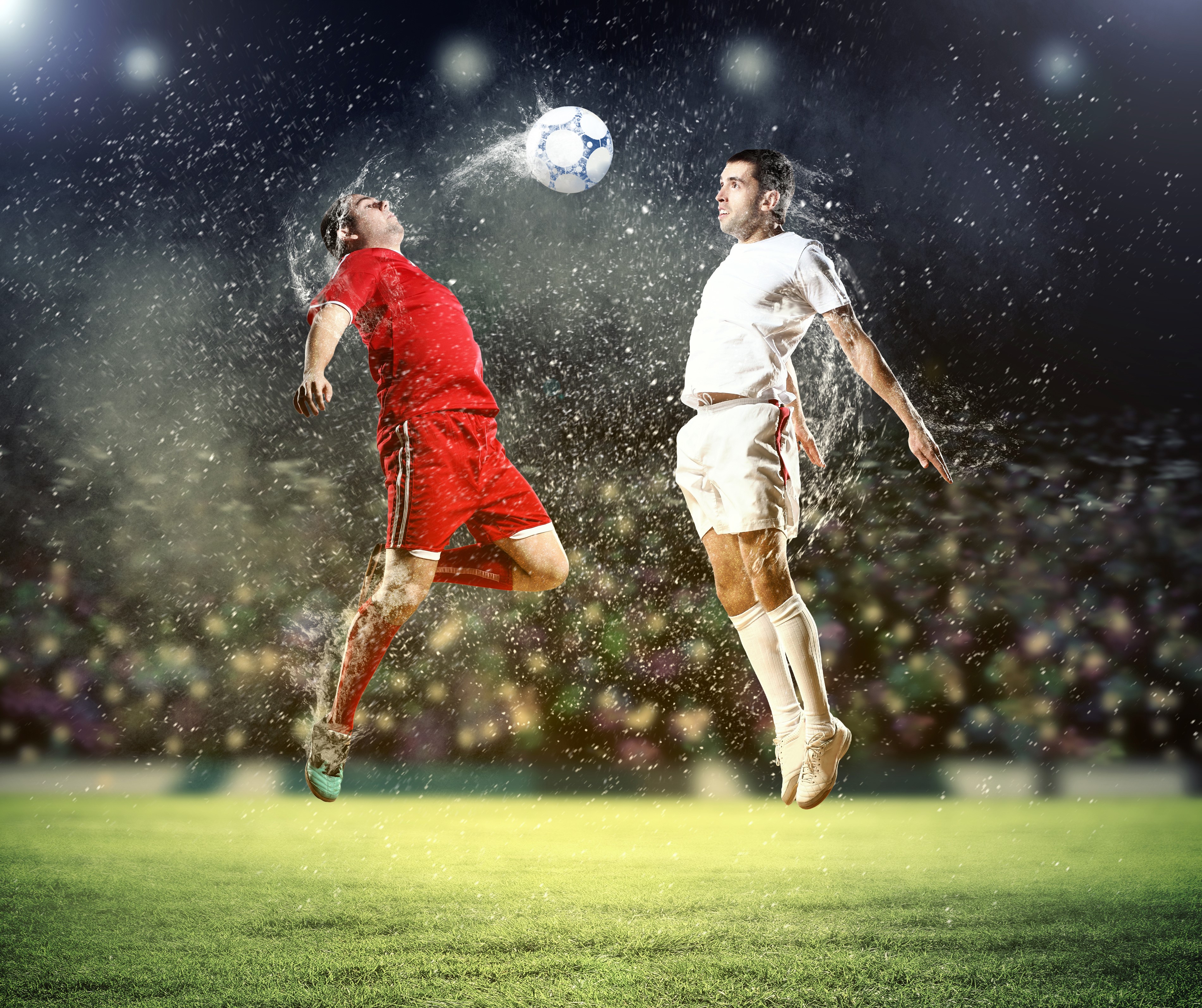 Two soccer players jumping to head the ball HD Wallpaper