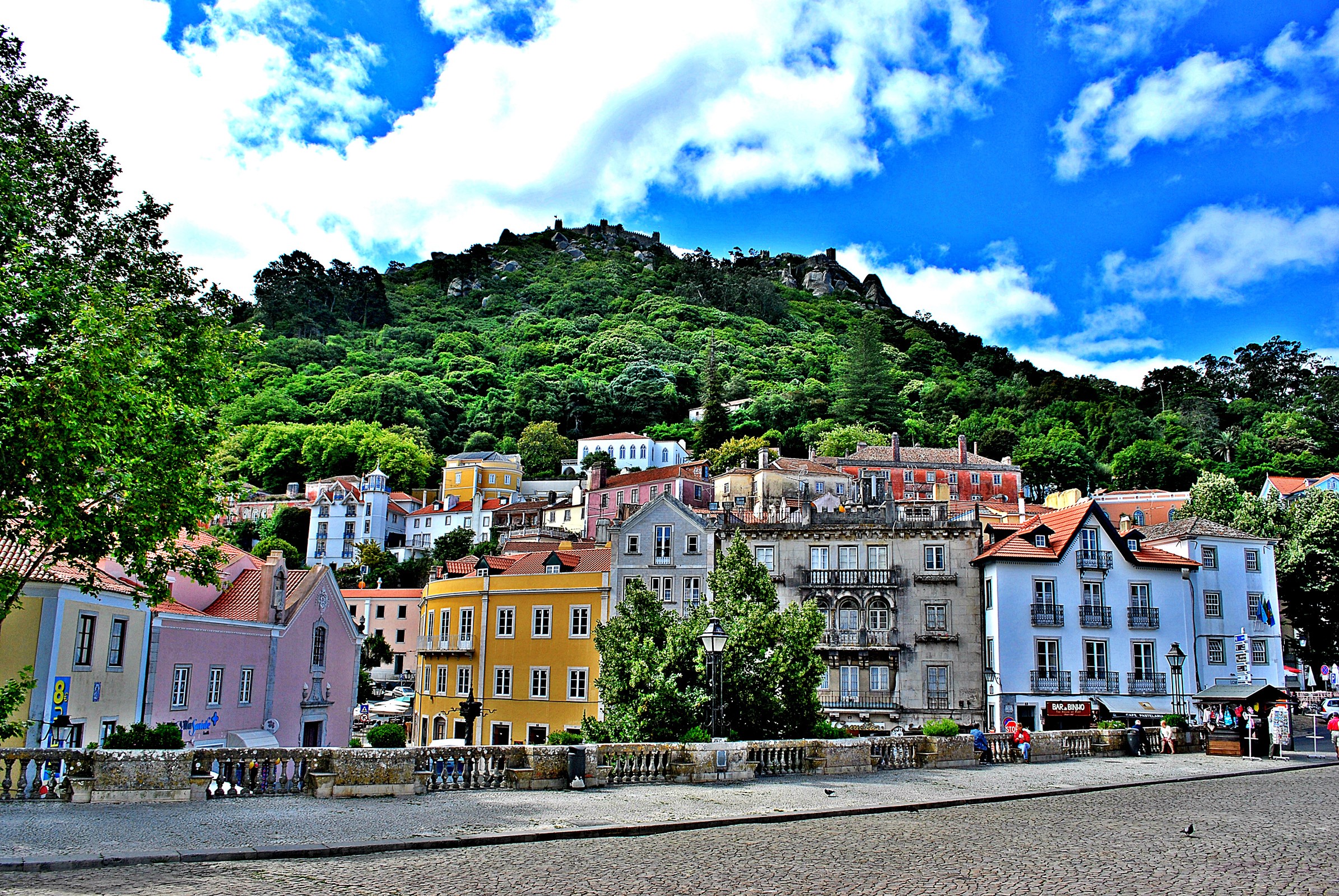 Colorful houses at the foot of a green mountain in Sintra, Portugal HD Wallpaper