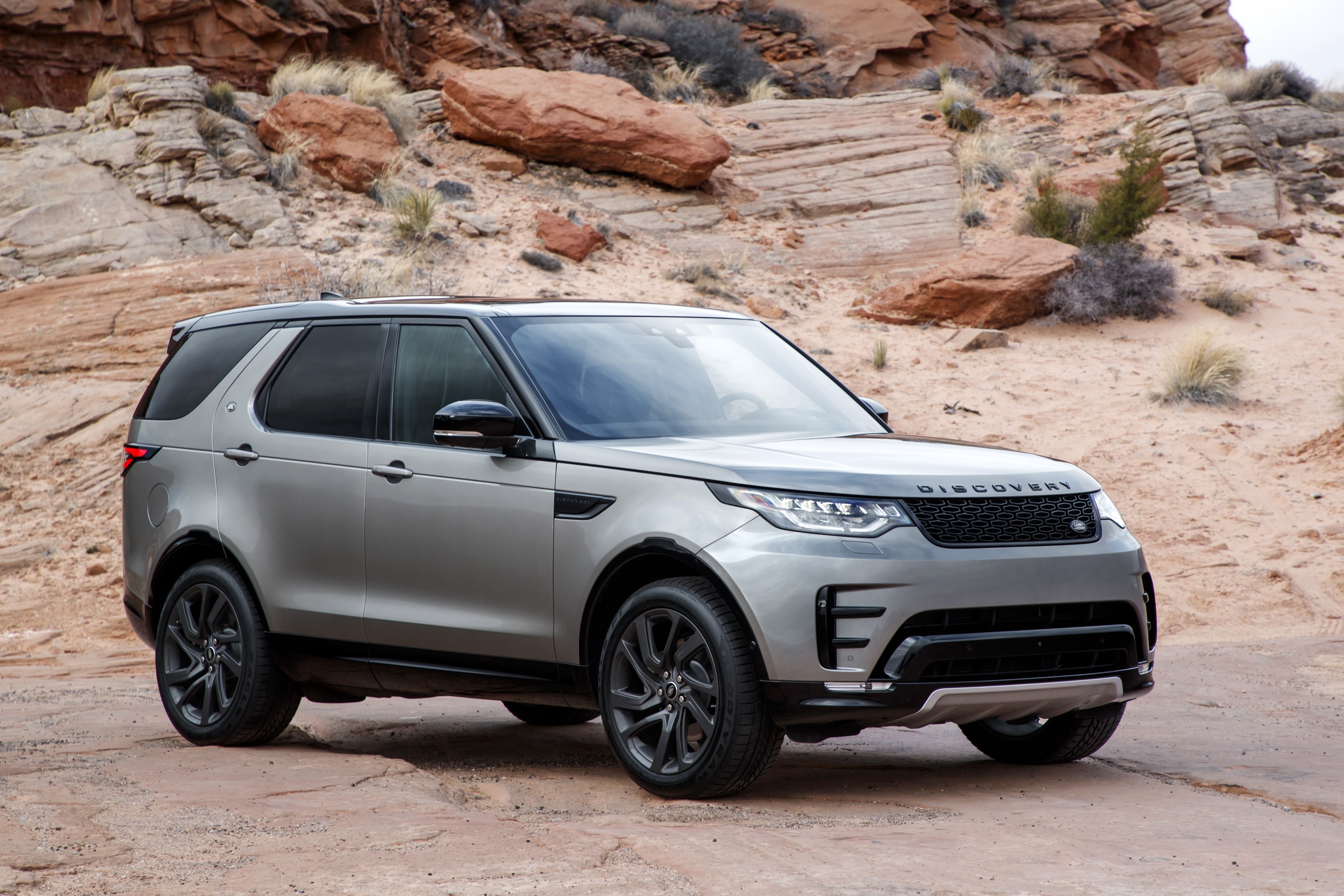Silver Land Rover Discovery SUV in desert landscape HD Wallpaper