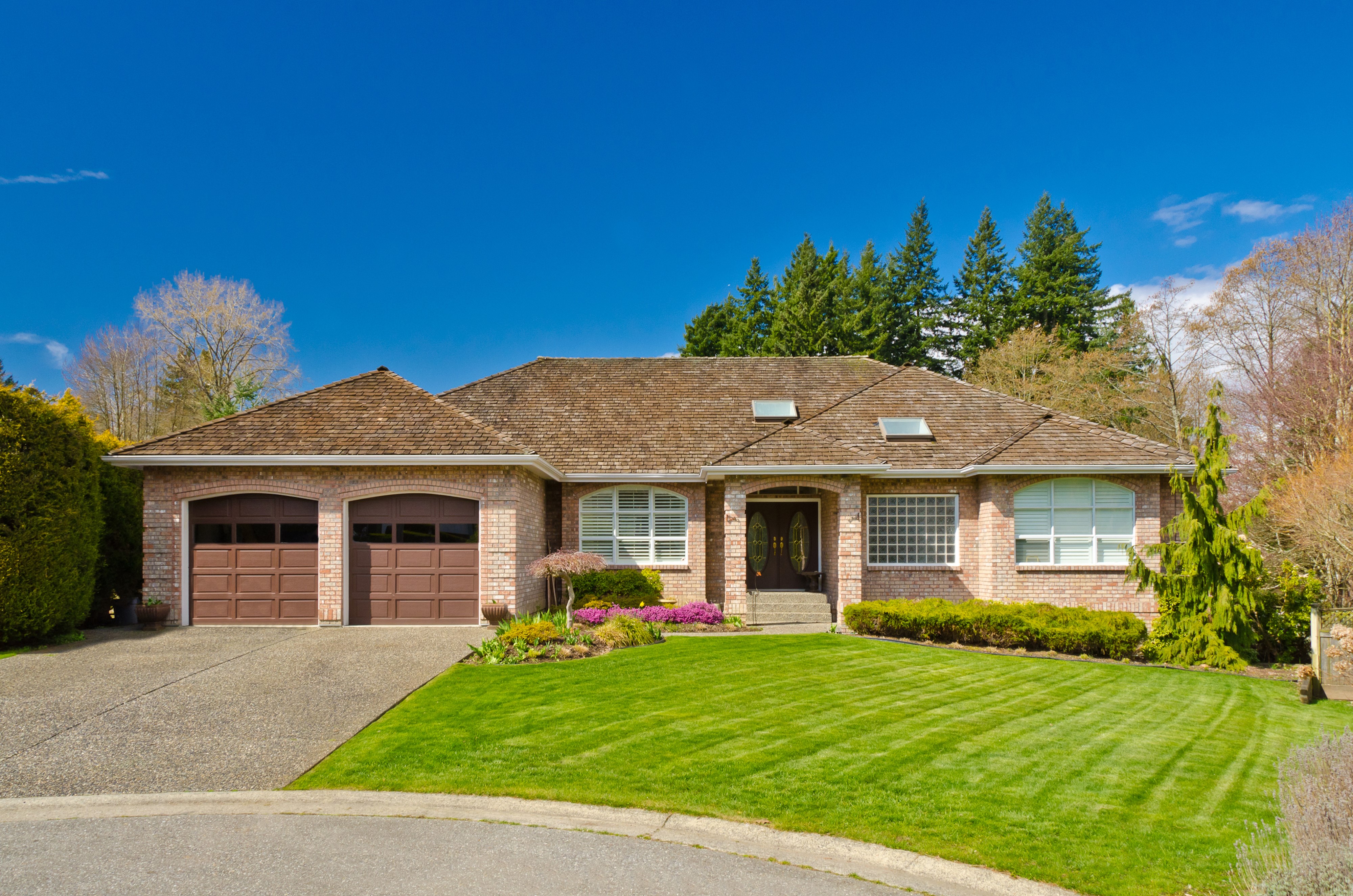 Brick house with garage and manicured lawn HD Wallpaper
