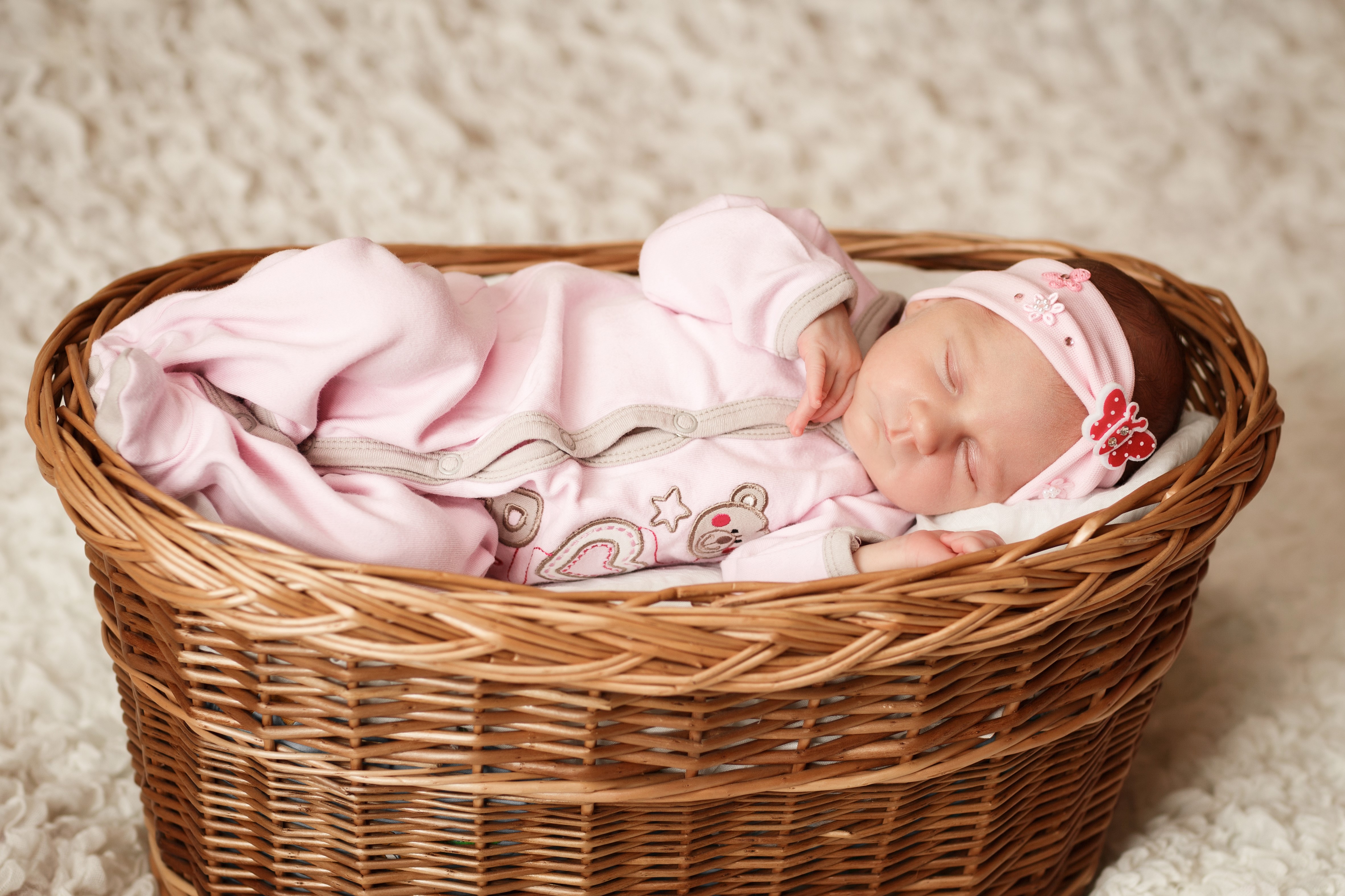 Infant sleeping in a wicker basket HD Wallpaper