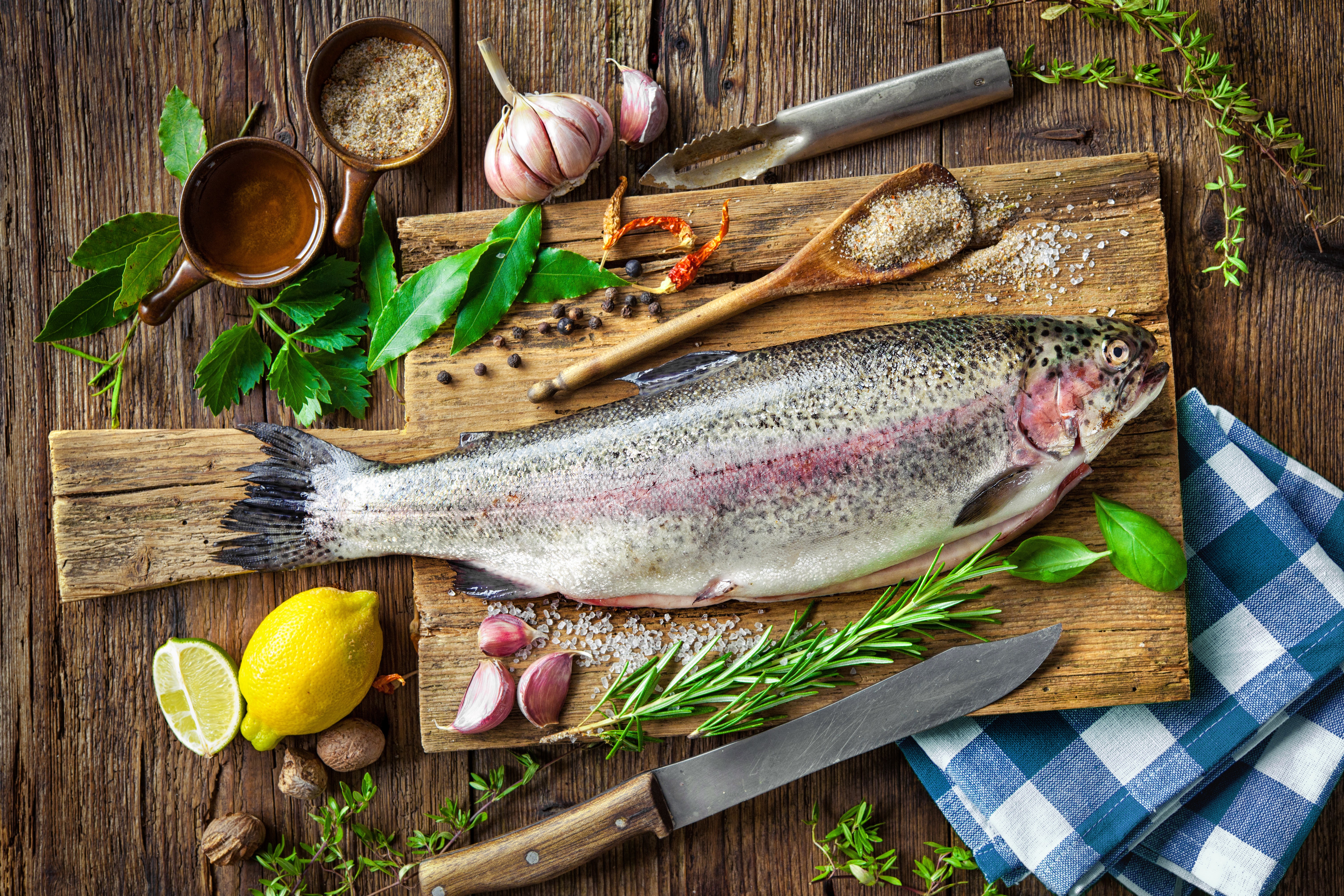 Still life of a rainbow trout with lemon, garlic, and spices HD Wallpaper