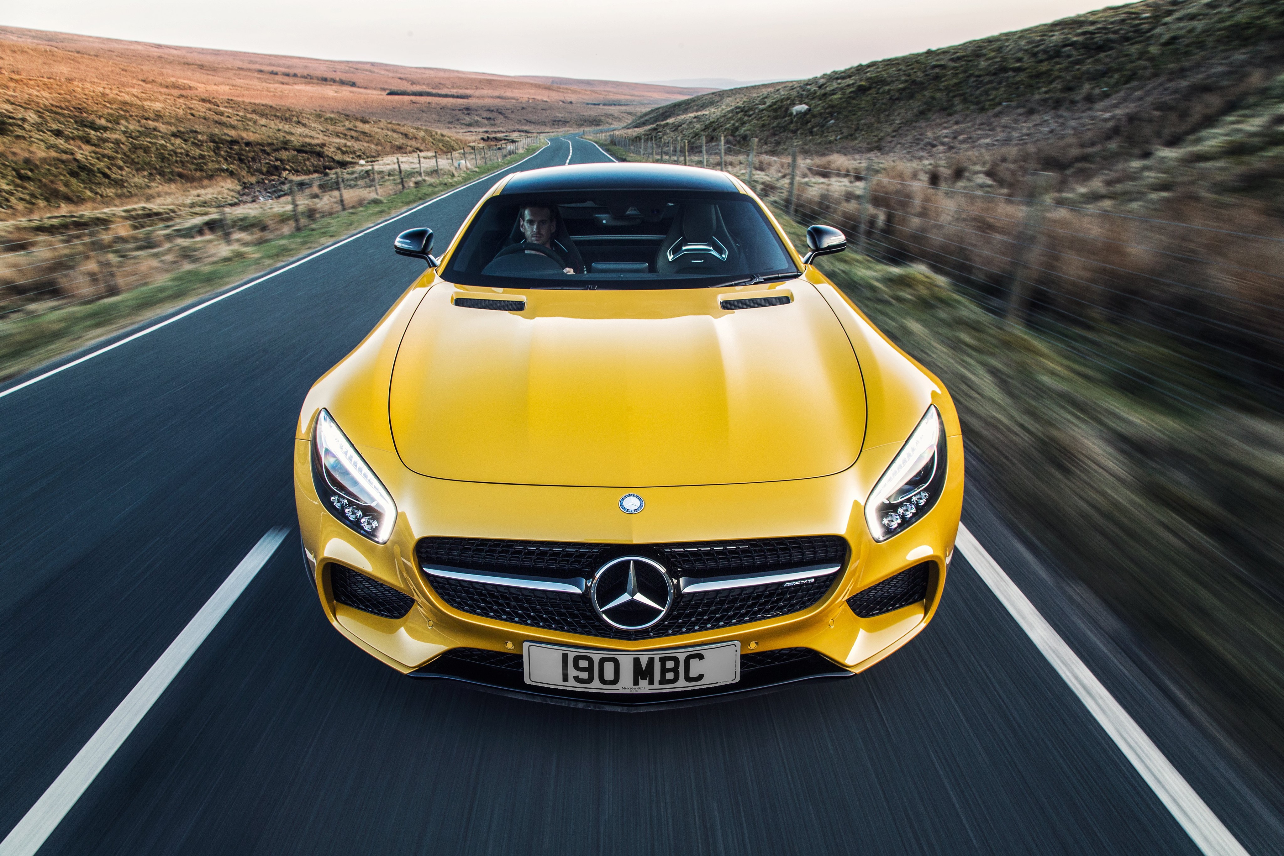 Yellow Mercedes-Benz AMG GT S driving on a road HD Wallpaper