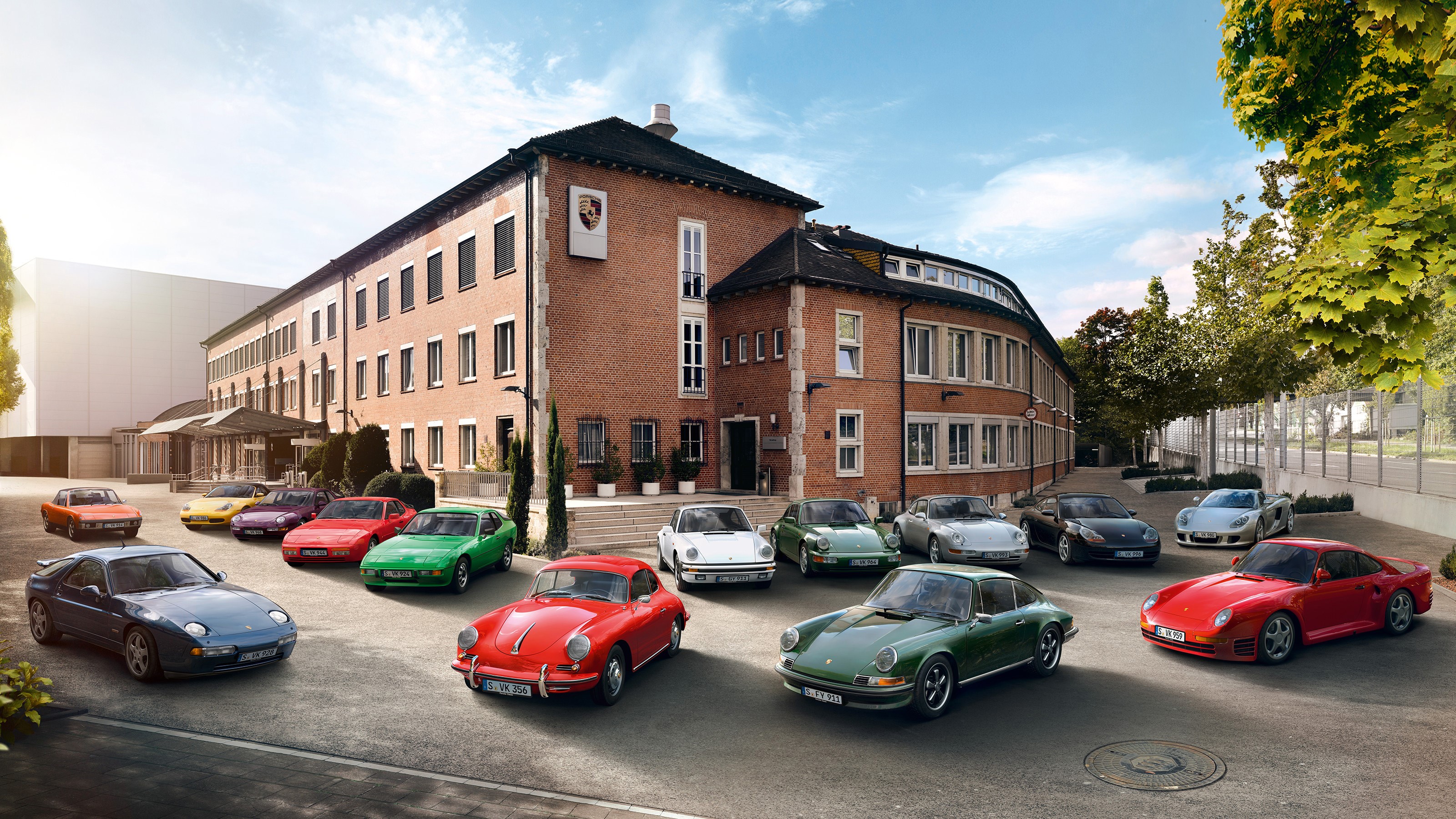Porsche cars parked in front of a brick building HD Wallpaper