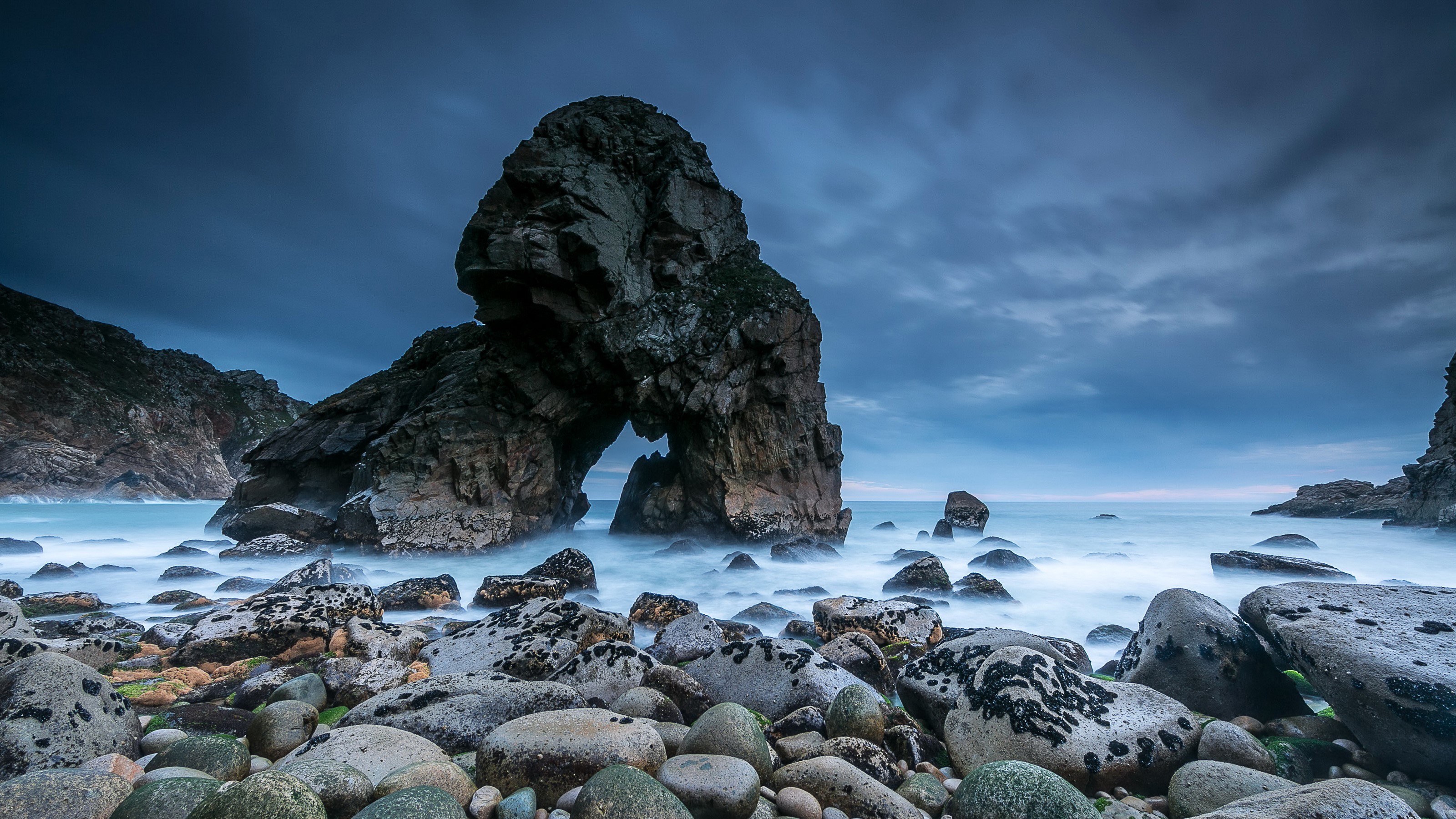 Rocky coast with sea arch and stormy sky HD Wallpaper