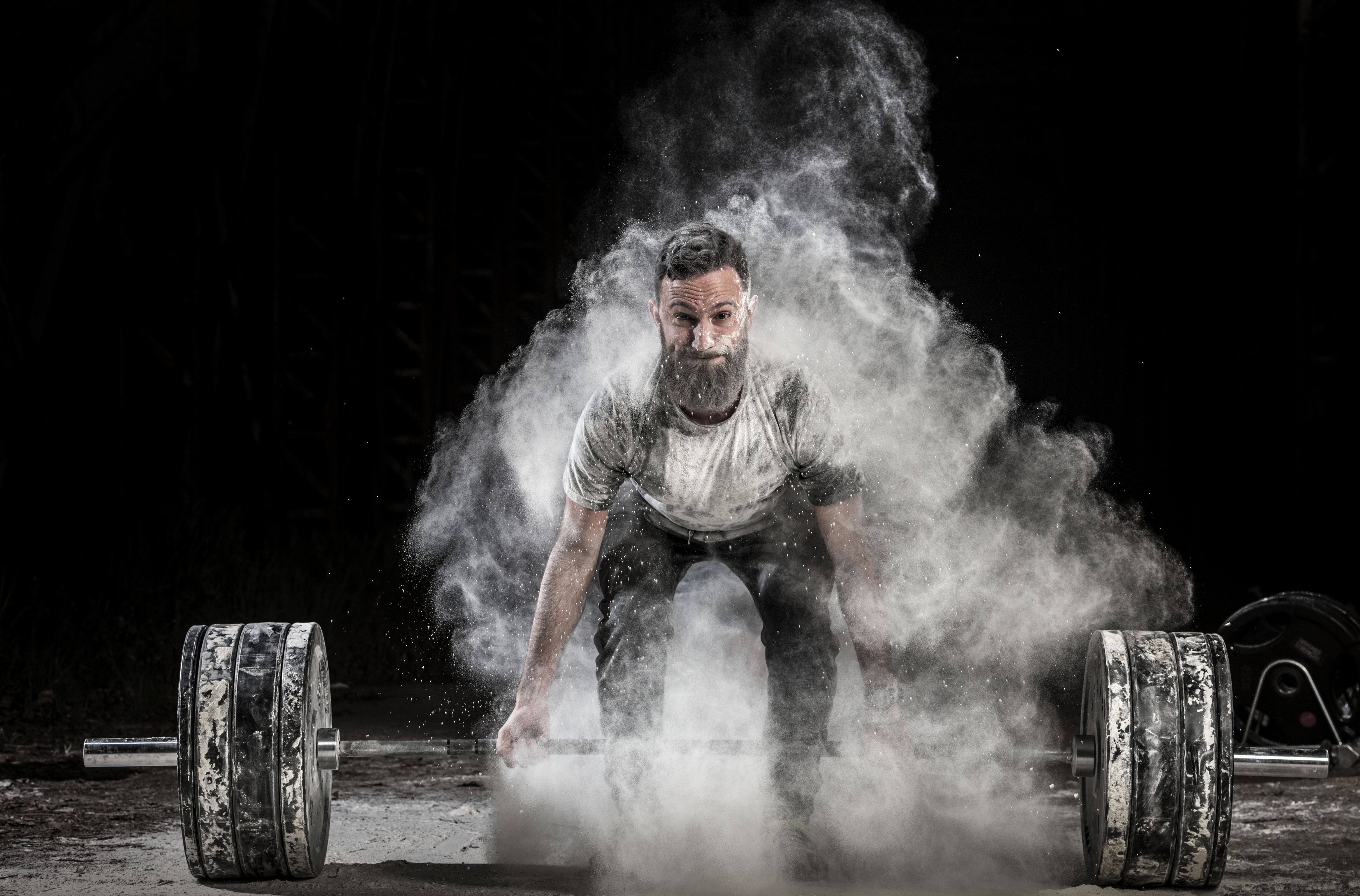 Man with beard lifting barbell with chalk dust HD Wallpaper