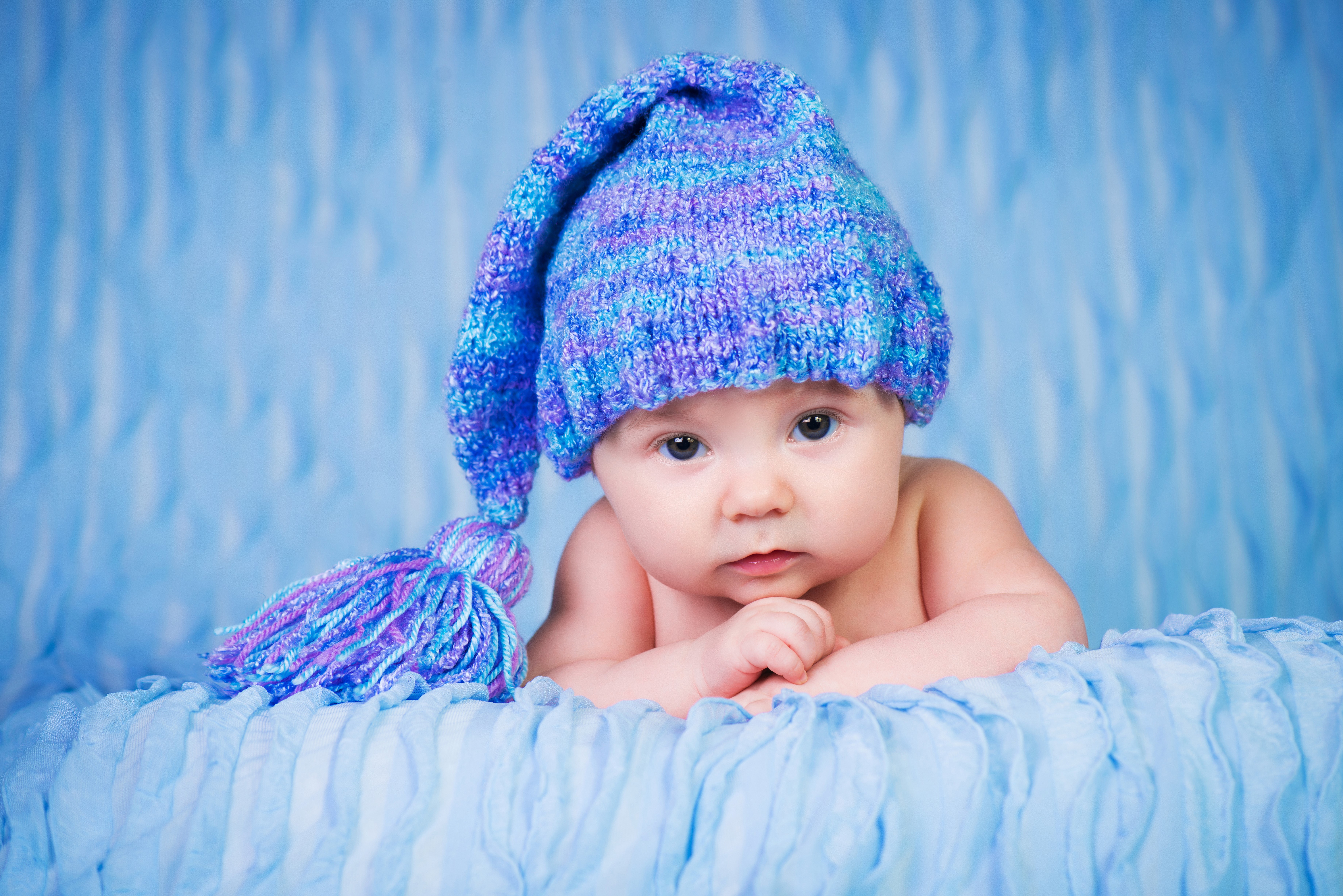 Baby wearing a blue knitted winter hat HD Wallpaper