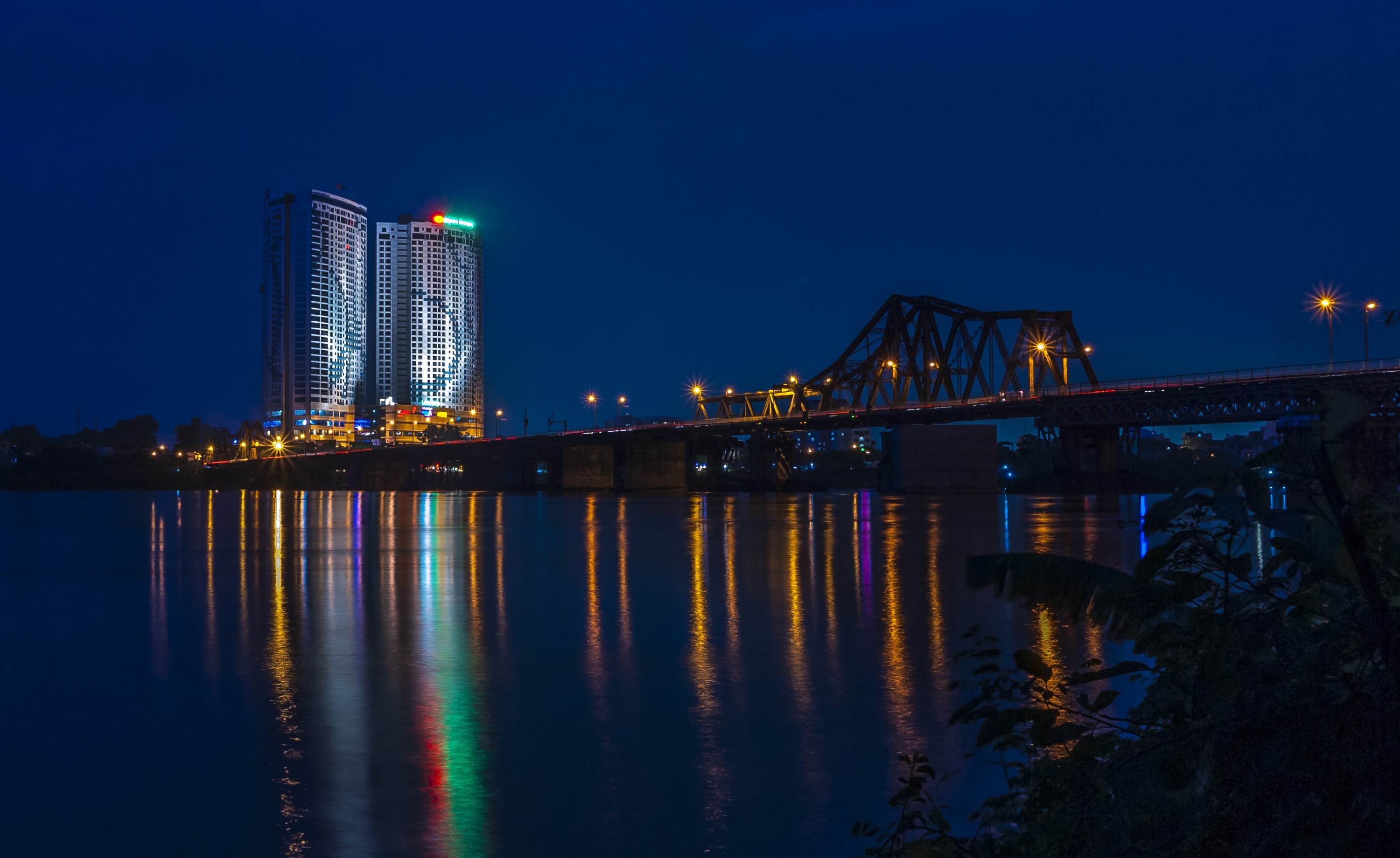 Long Bien Bridge and buildings over river at night in Ha Noi, Vietnam HD Wallpaper