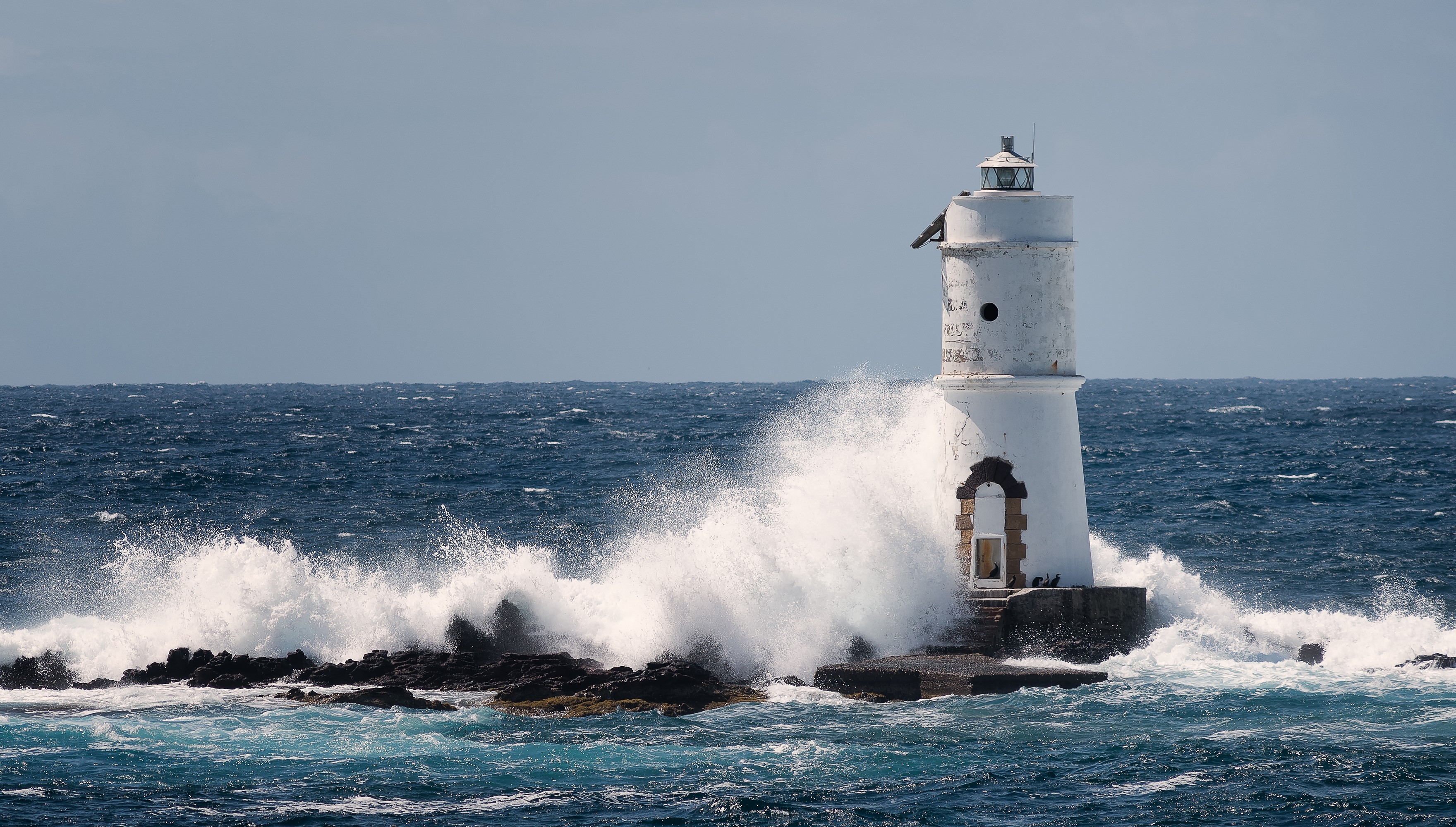 Mangiabarche Lighthouse, Calasetta, Italy, with waves crashing HD Wallpaper