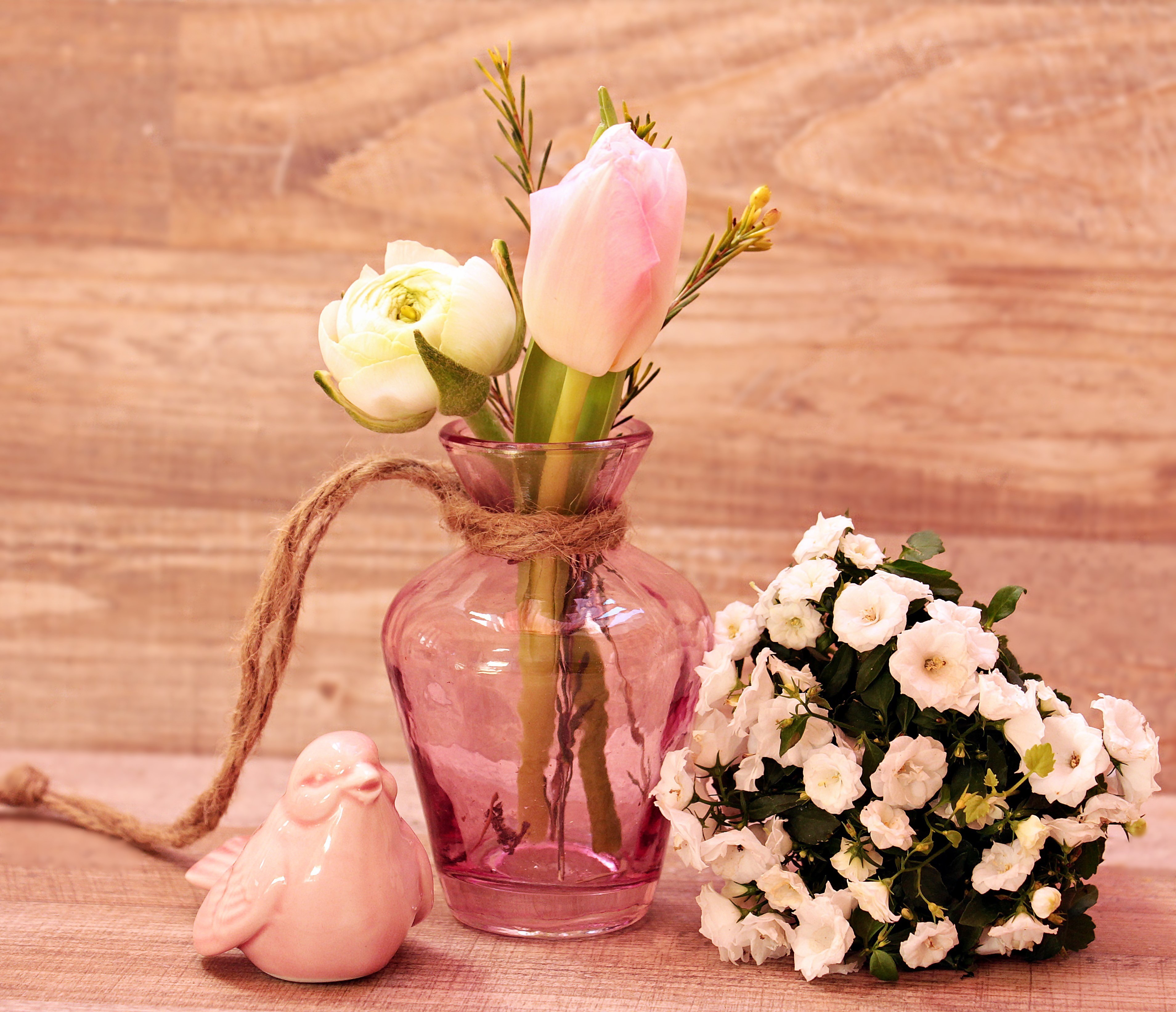 Pink vase with tulips, ranunculus, and white flowers with a pink bird figurine HD Wallpaper