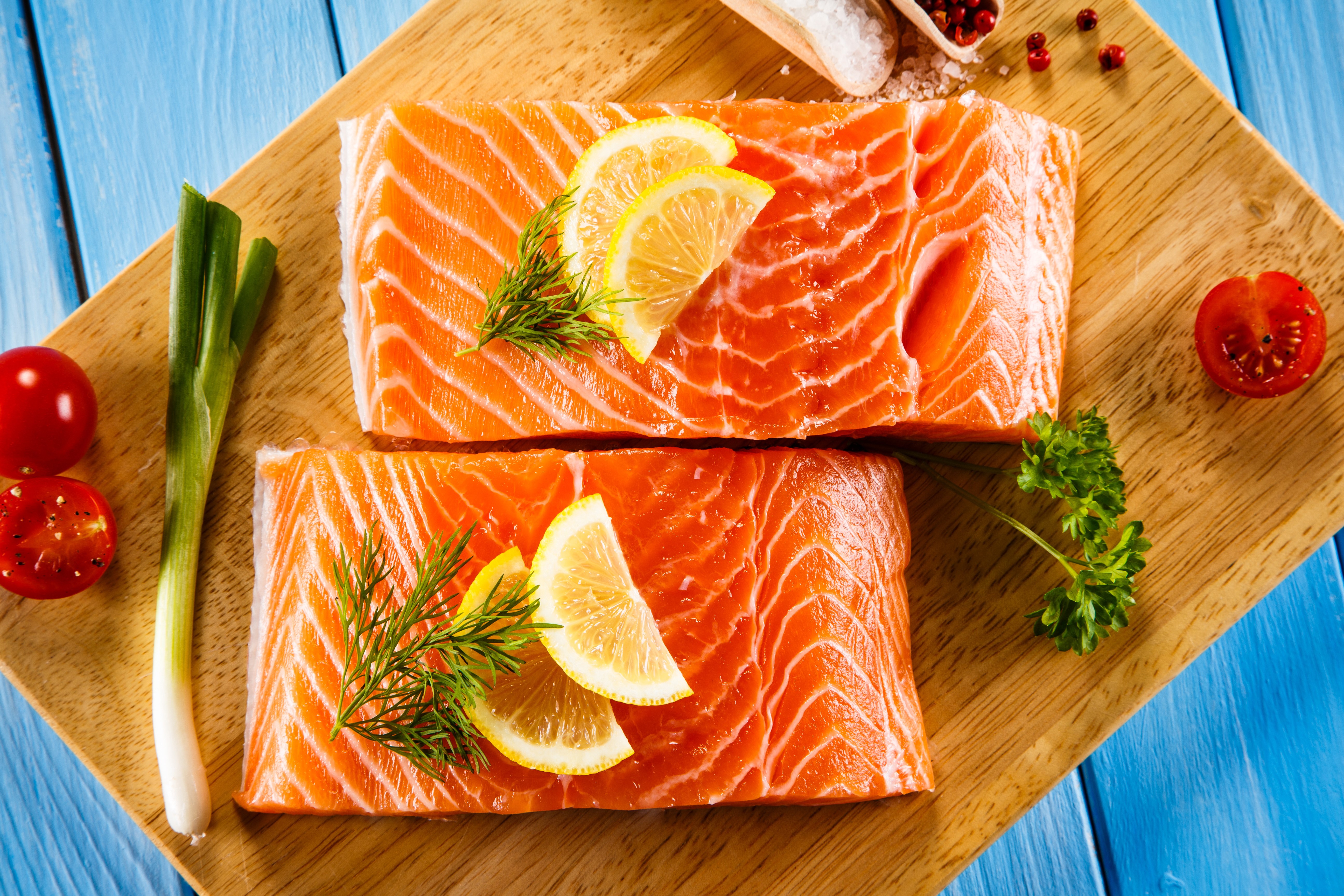 Salmon fillets with lemon and herbs on a cutting board HD Wallpaper
