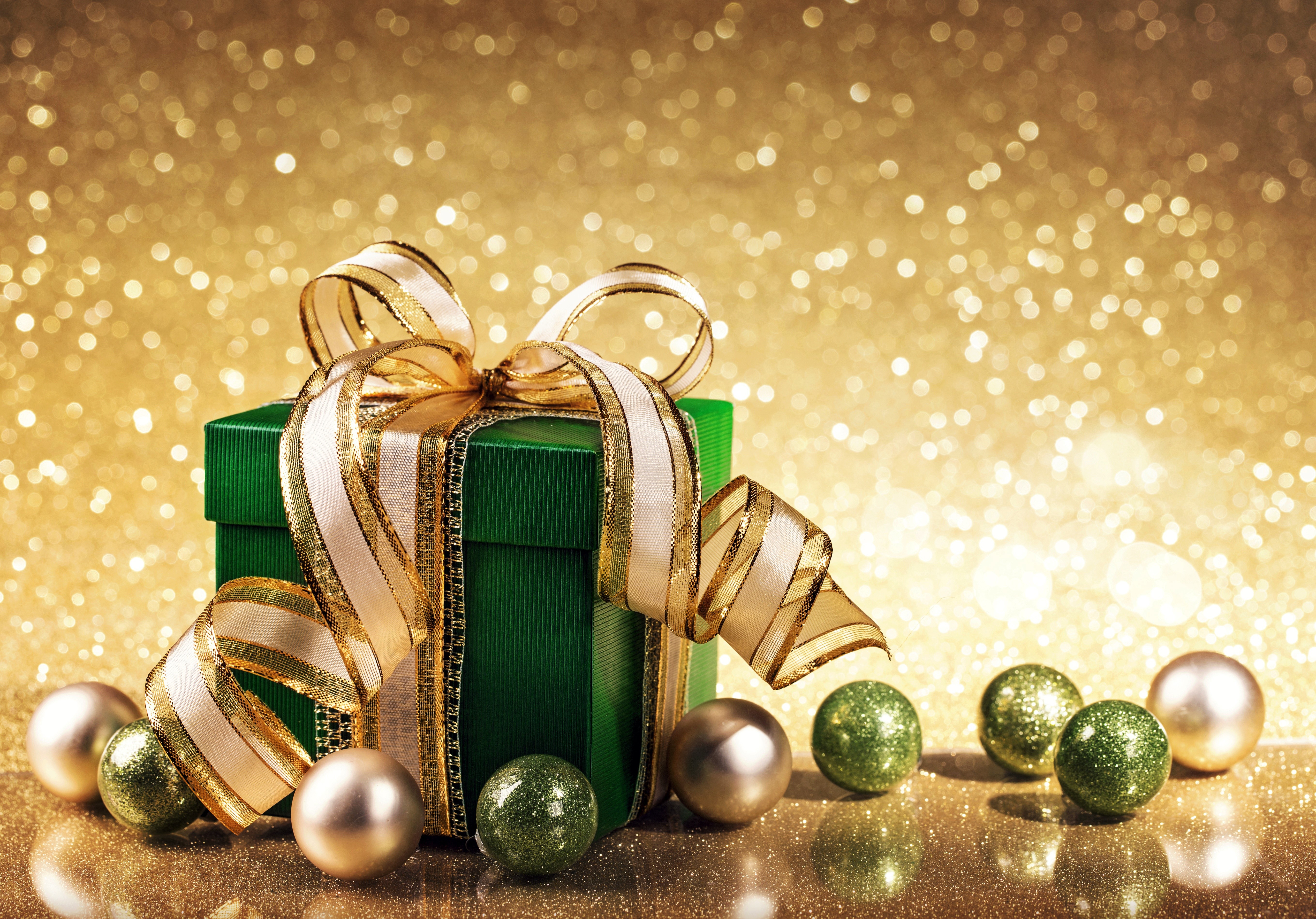 Green gift box with gold ribbon and ornaments HD Wallpaper