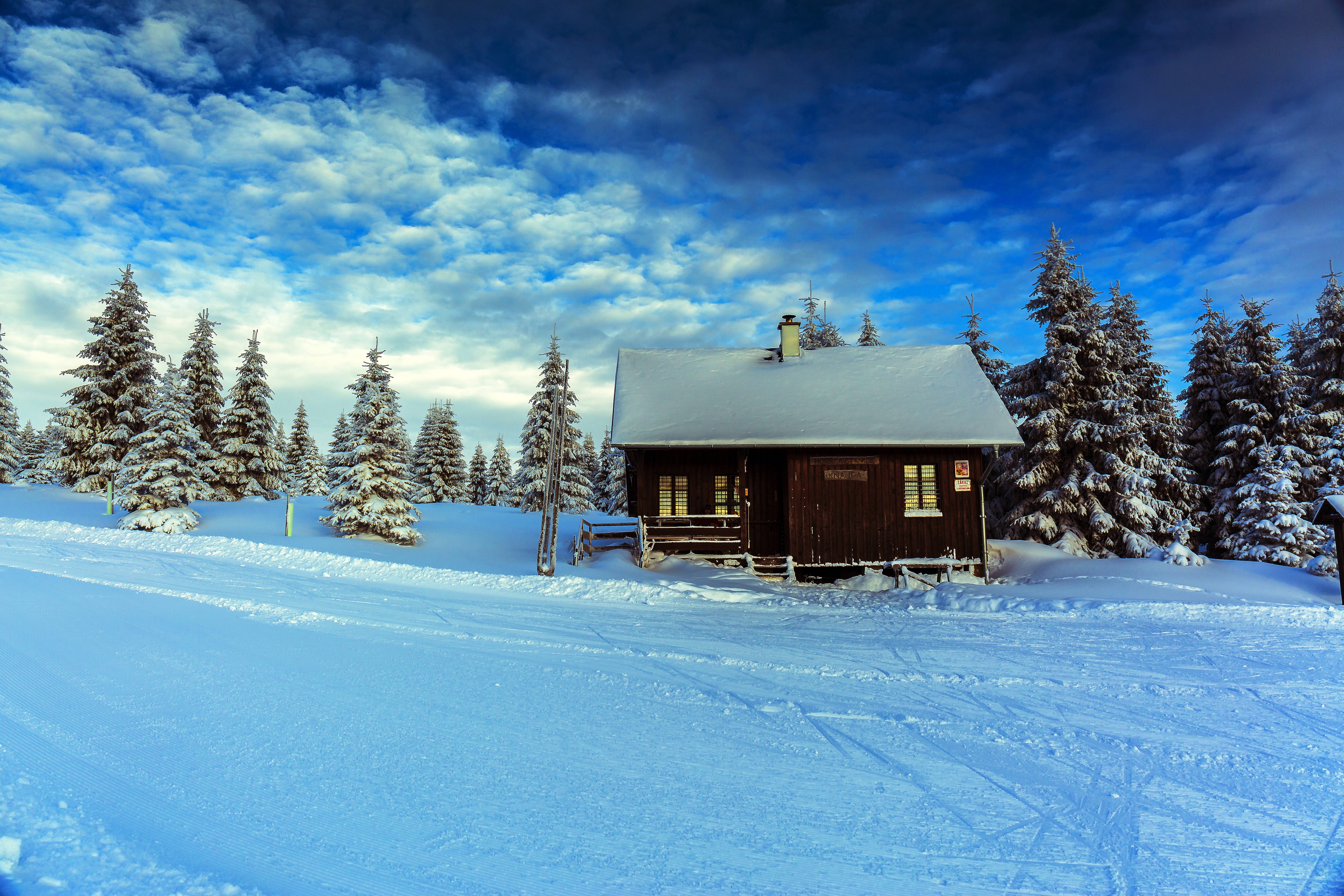 Winter cabin in snowy forest with dramatic sky HD Wallpaper