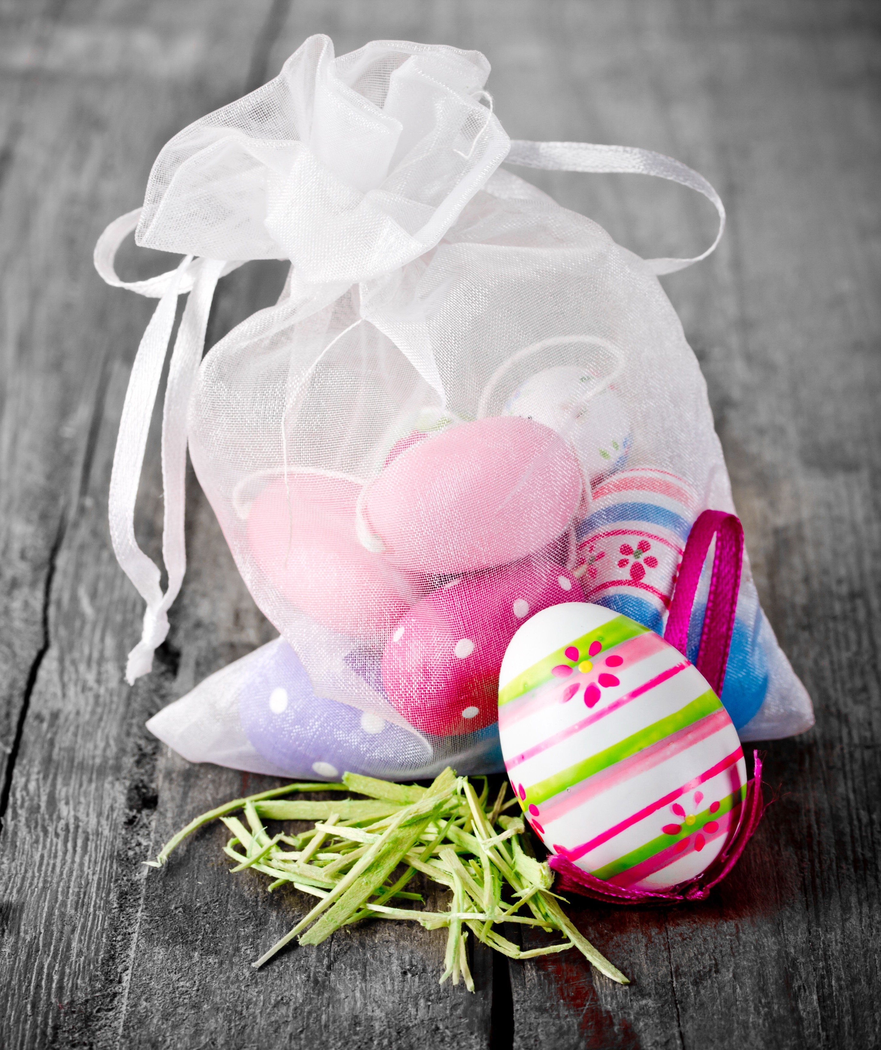 Easter eggs in a white organza bag on wood HD Wallpaper