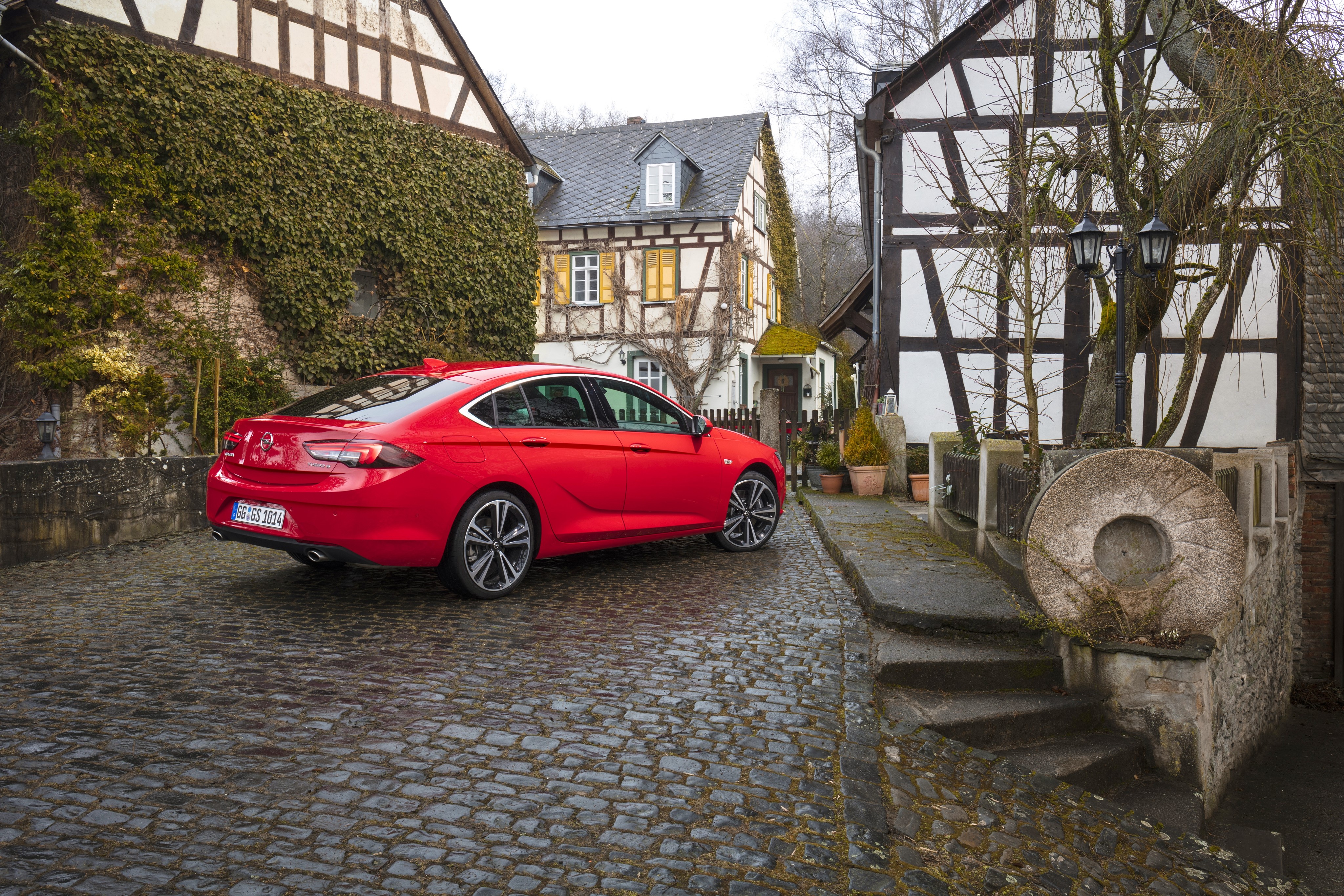 Red Opel Insignia on Cobblestone Street HD Wallpaper