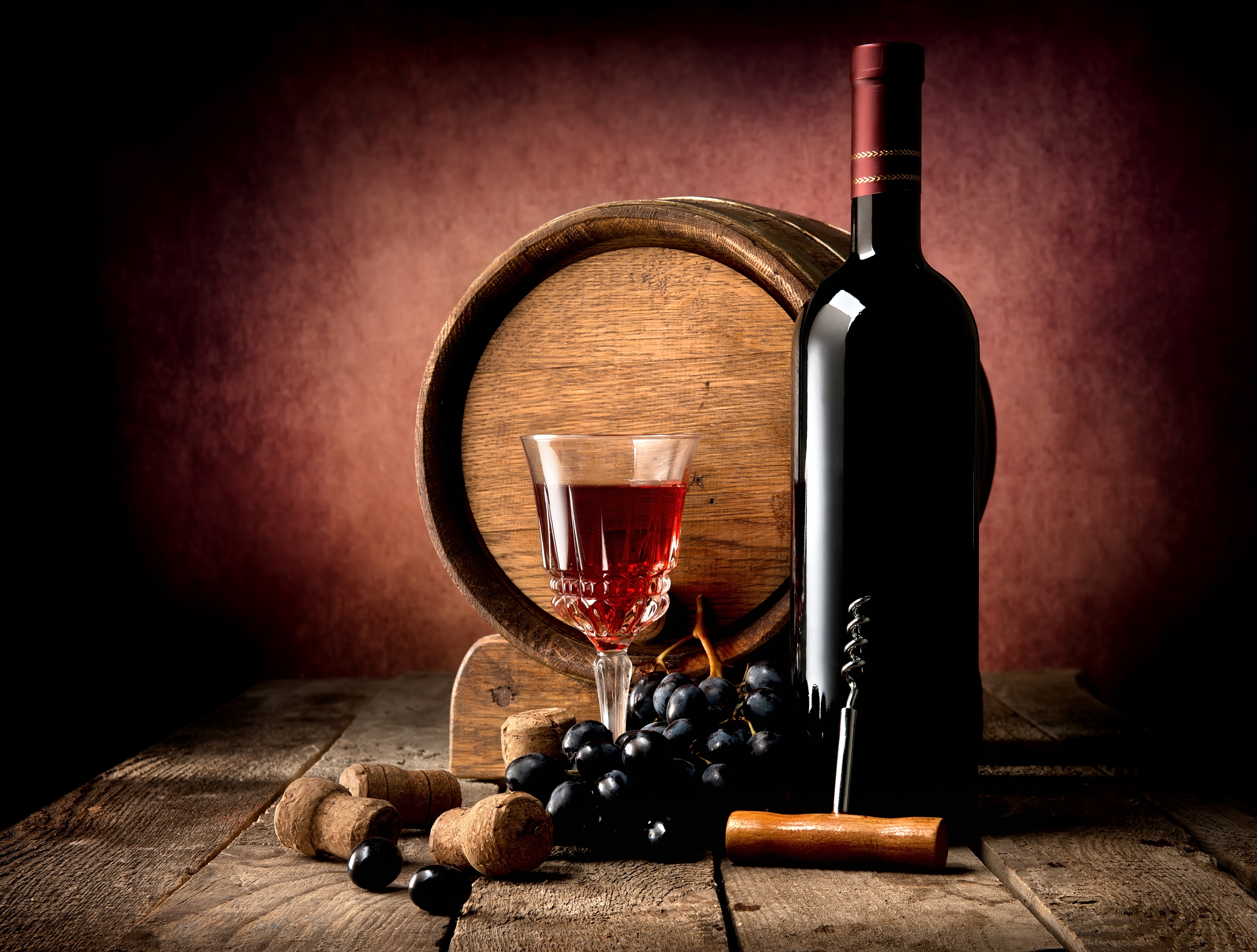 Wine bottle, glass, barrel, and grapes on wood HD Wallpaper