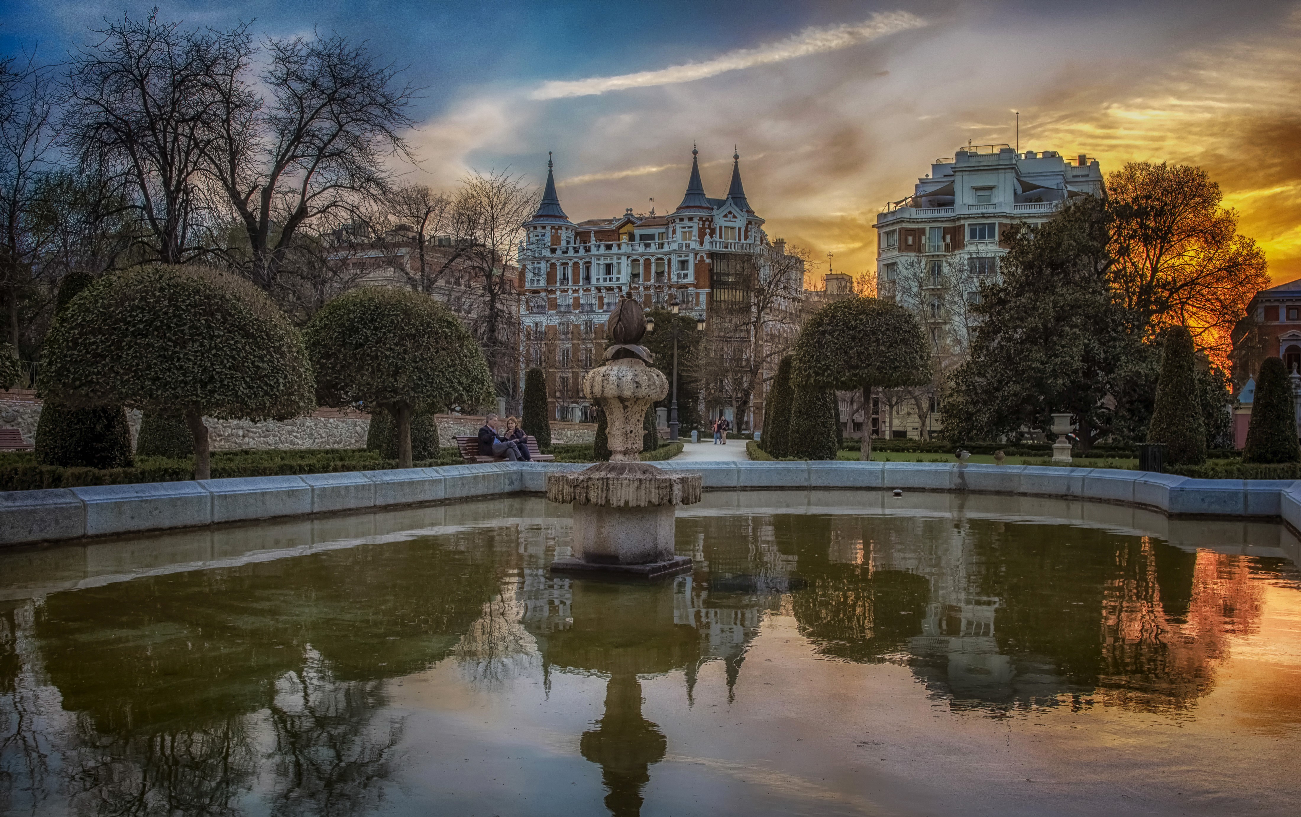 Fountain and buildings in Retiro Park, Madrid at sunset HD Wallpaper