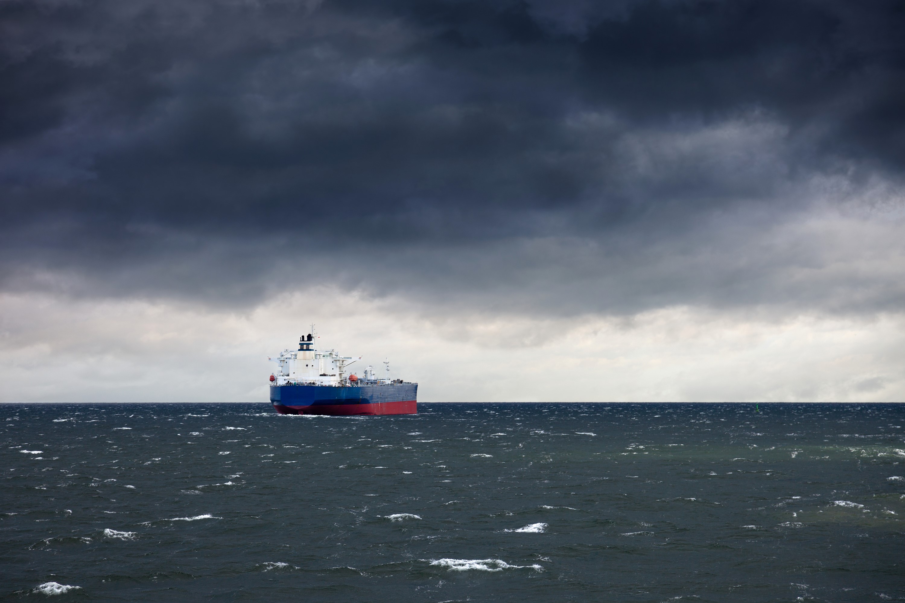 Tanker ship sailing on a rough sea under stormy clouds HD Wallpaper