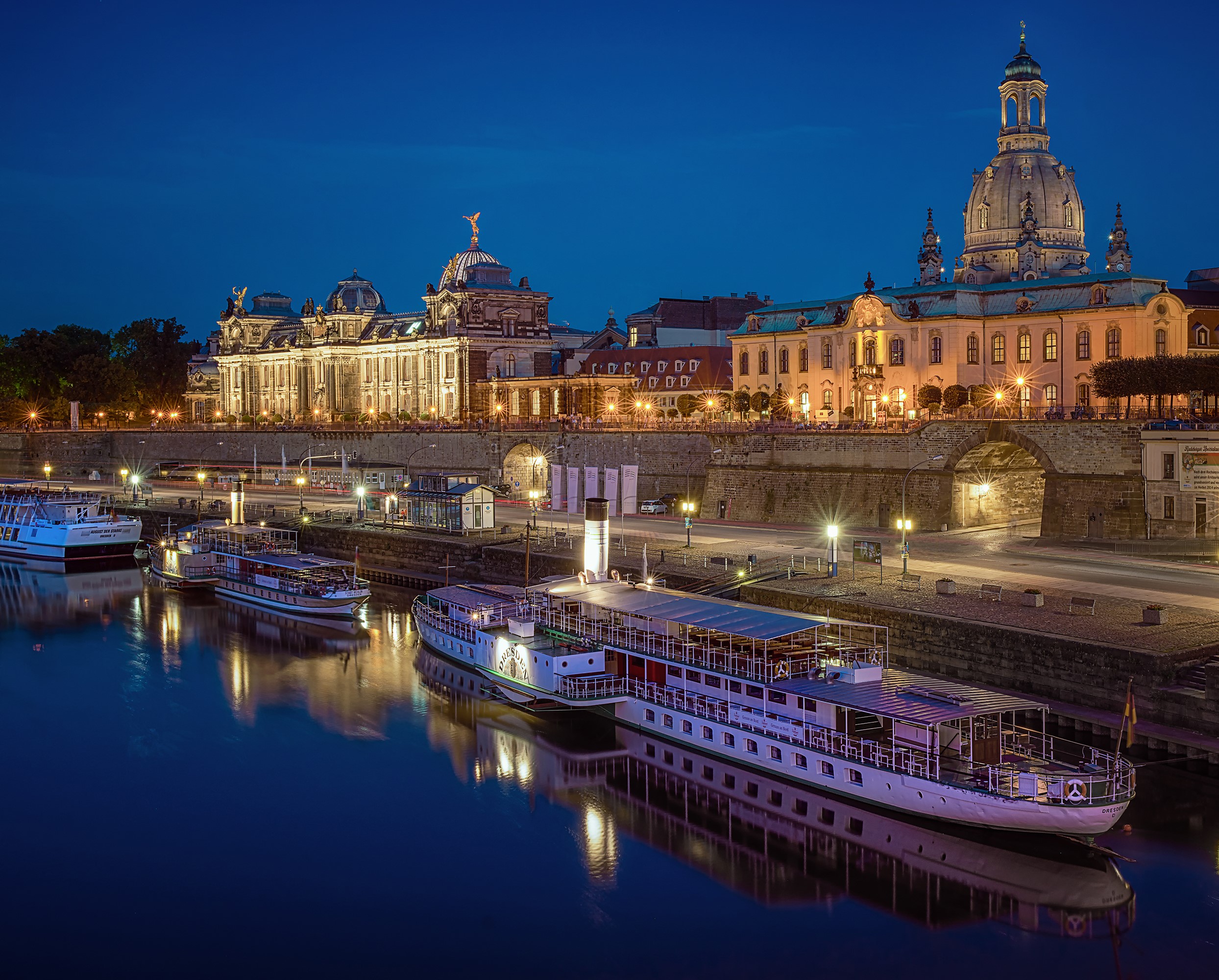 Dresden, Germany riverfront with boats and illuminated buildings at night HD Wallpaper