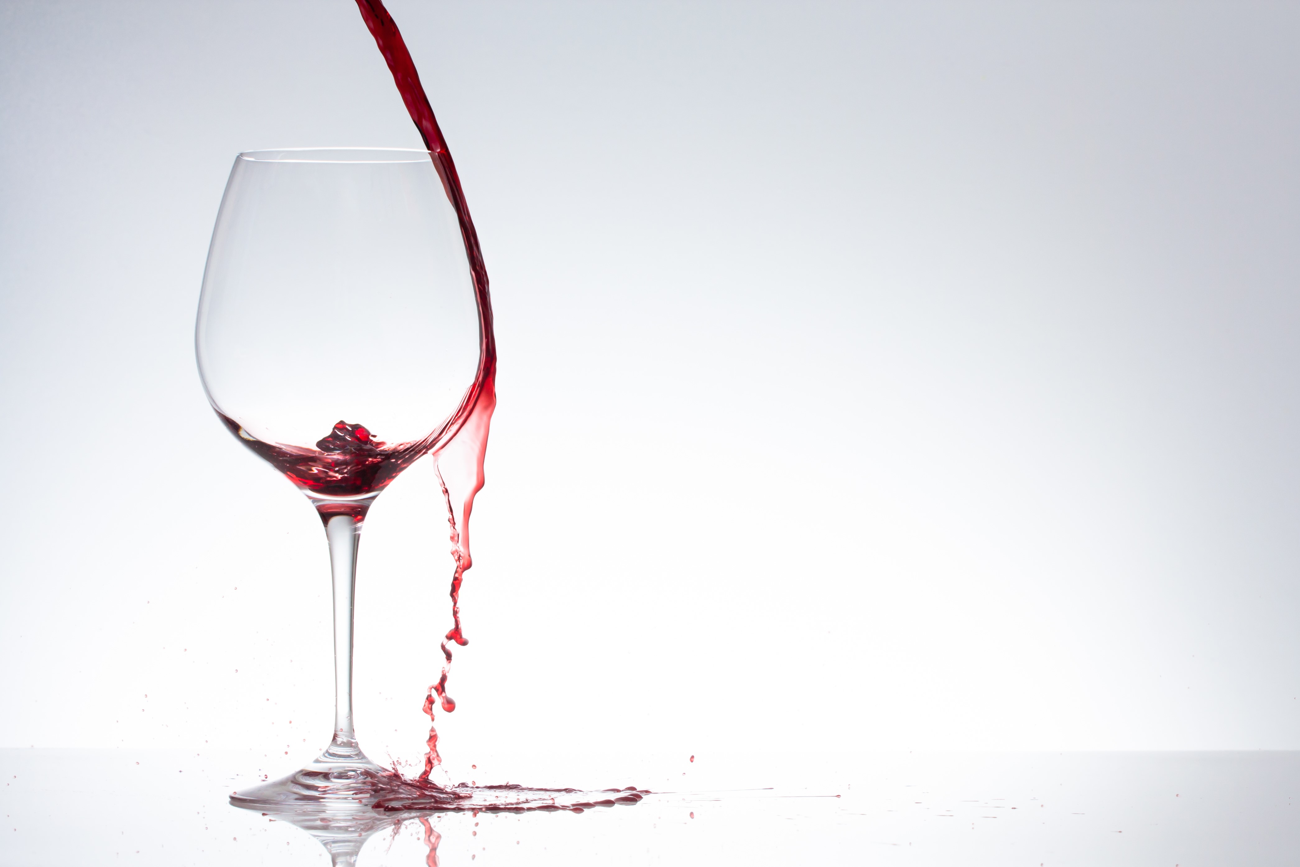 Red wine pouring into a wine glass HD Wallpaper