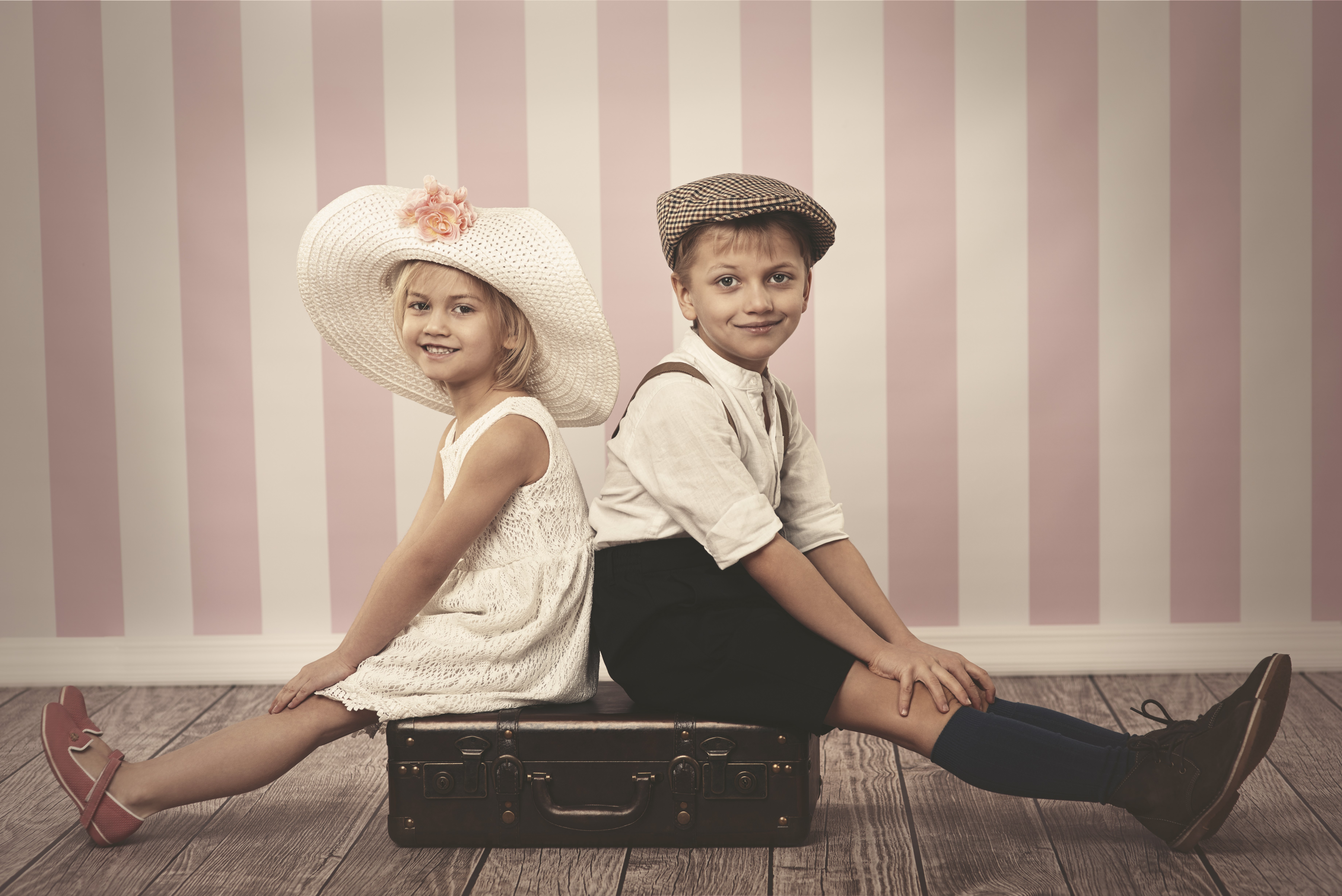 Two children sitting on a suitcase HD Wallpaper