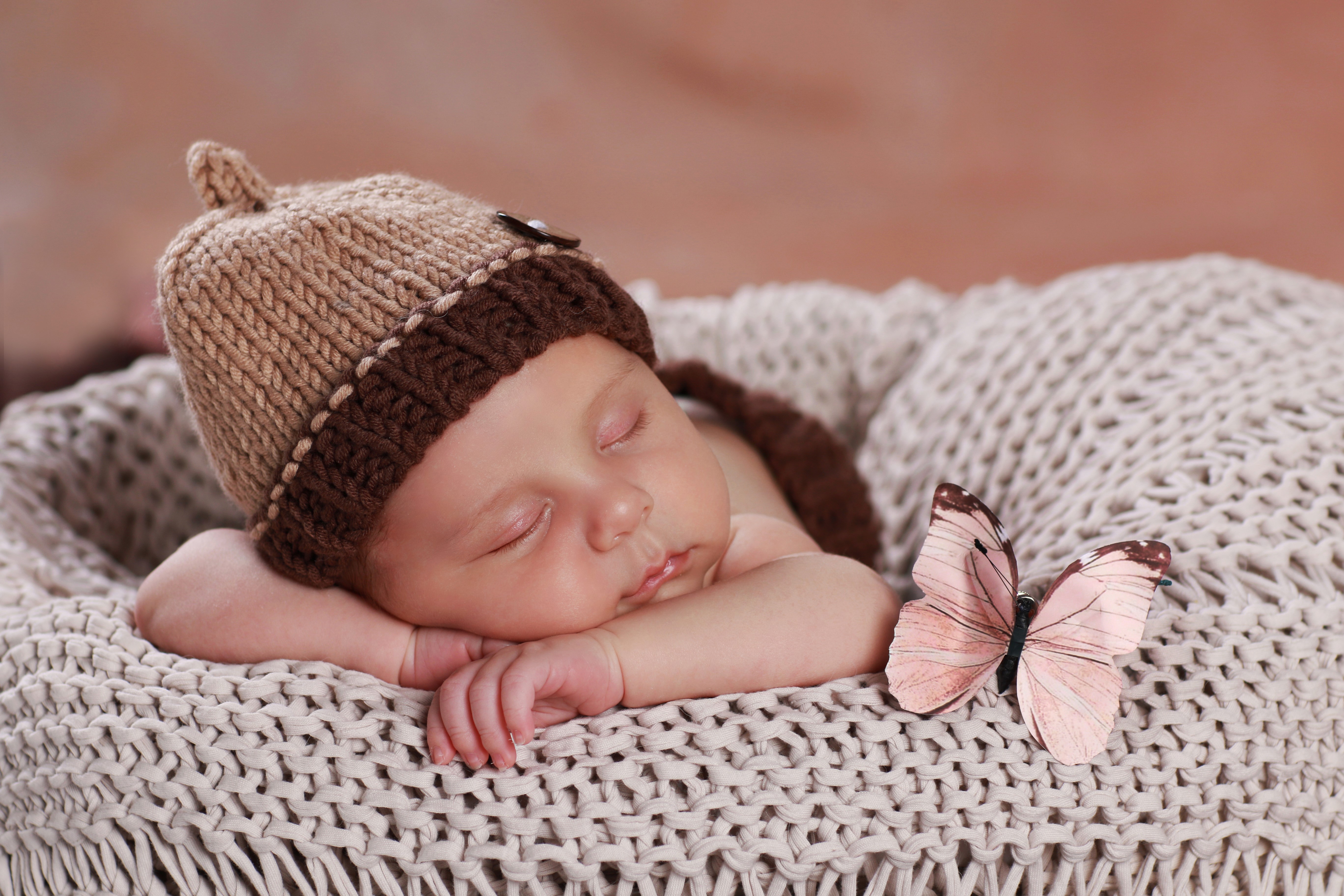 Infant sleeping in a basket with a butterfly HD Wallpaper