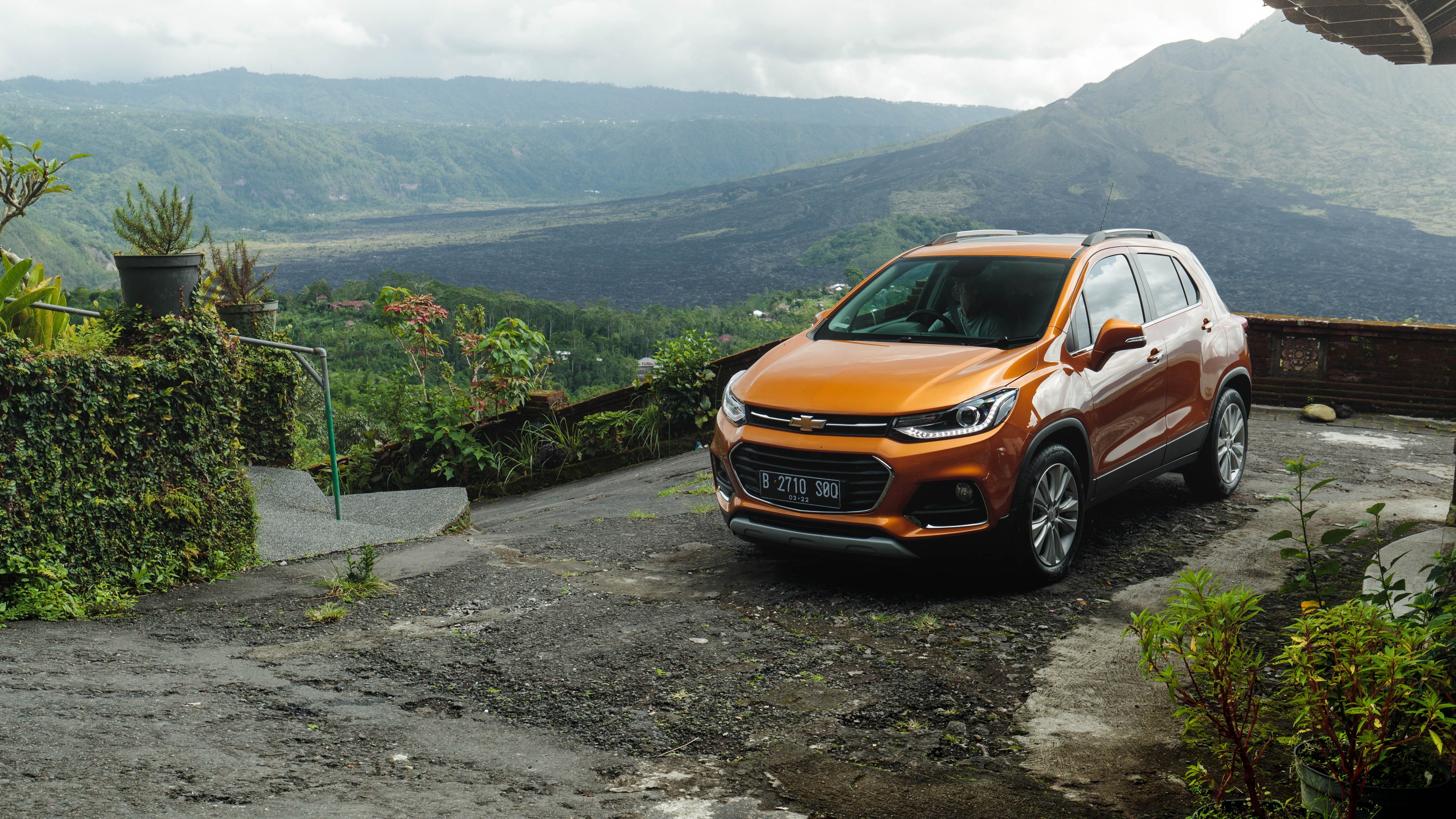 Orange Chevrolet Trax parked with volcanic landscape HD Wallpaper
