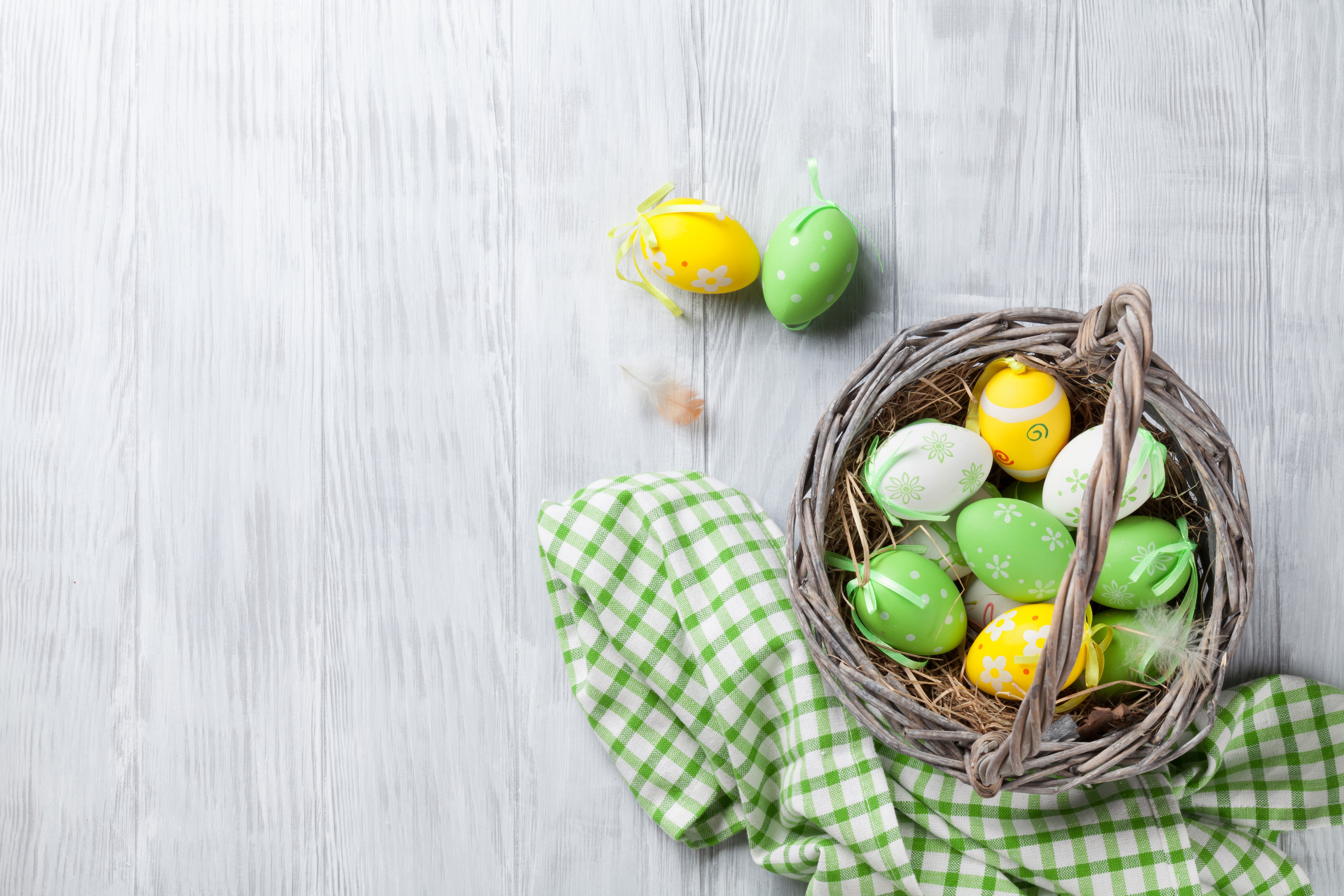 Easter eggs in a wicker basket on wood planks HD Wallpaper