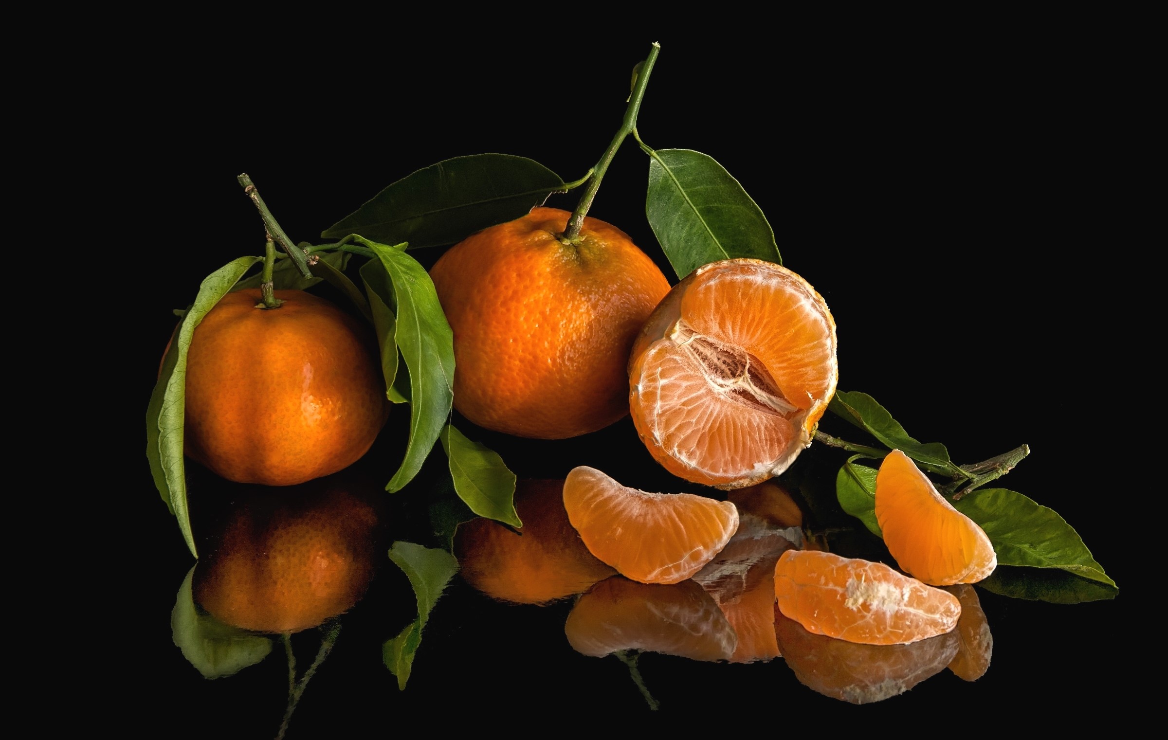 Tangerines with leaves on a black background HD Wallpaper