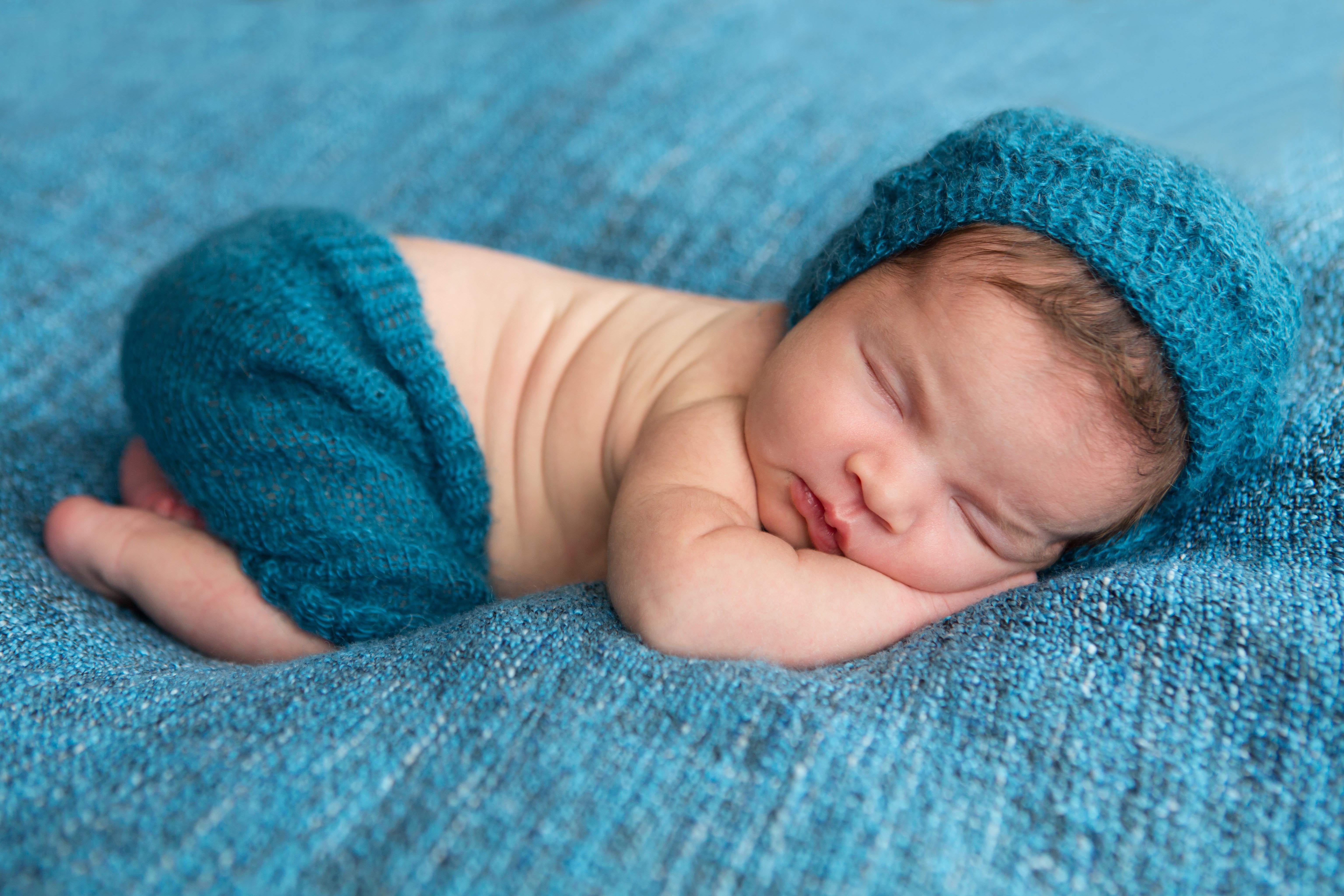 Newborn baby sleeping in a blue hat and pants HD Wallpaper