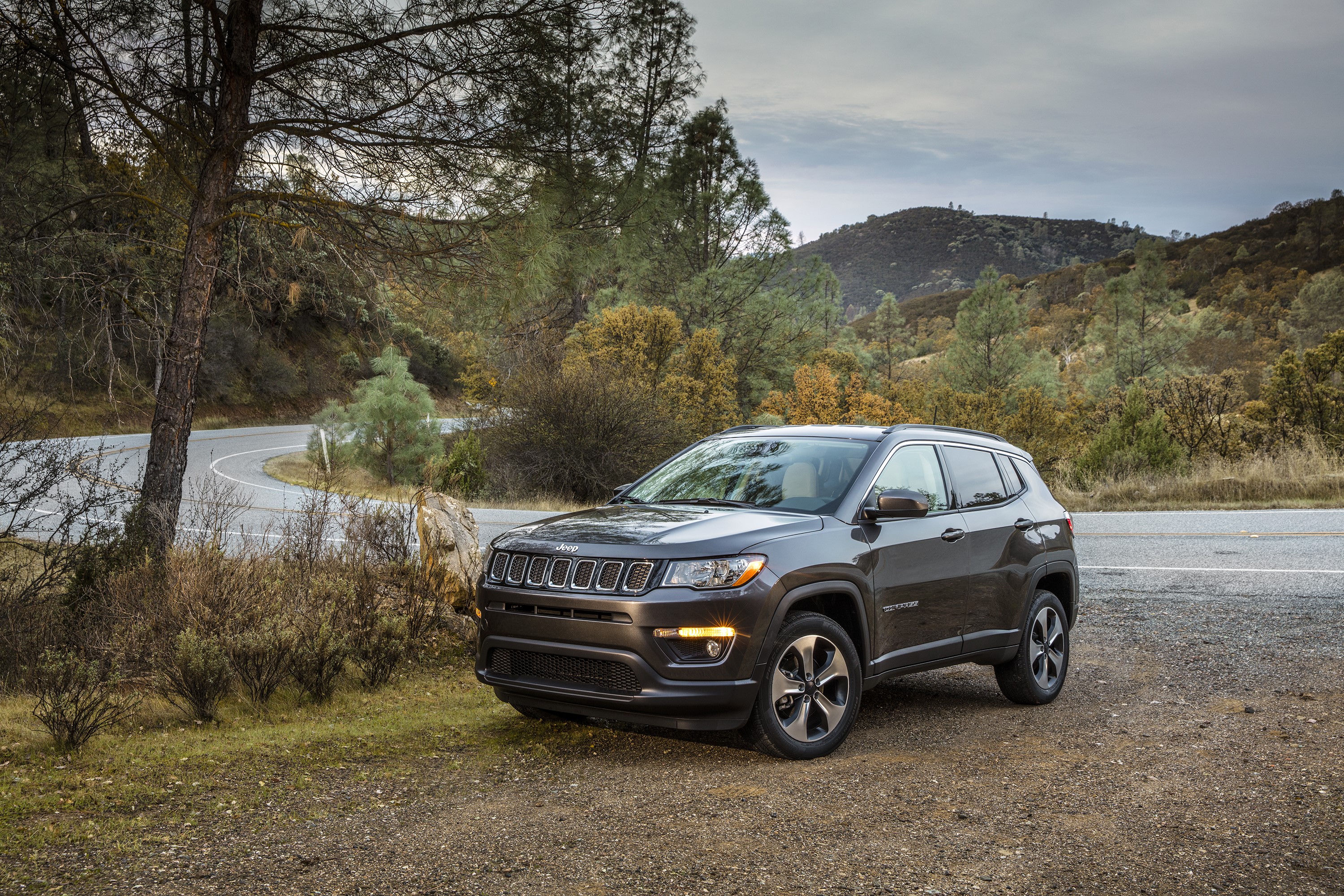 Grey 2017 Jeep Compass Latitude on a winding road HD Wallpaper