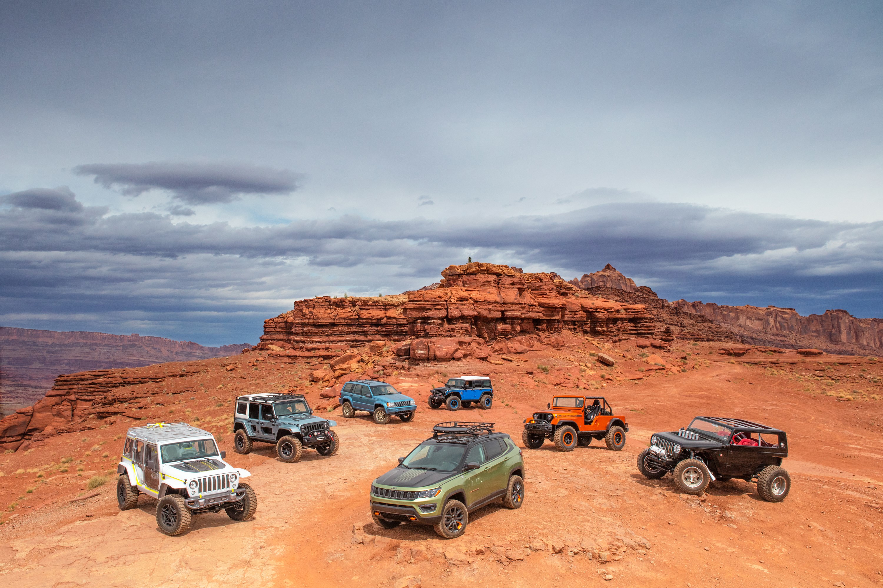 Jeep vehicles parked on a rocky desert landscape HD Wallpaper