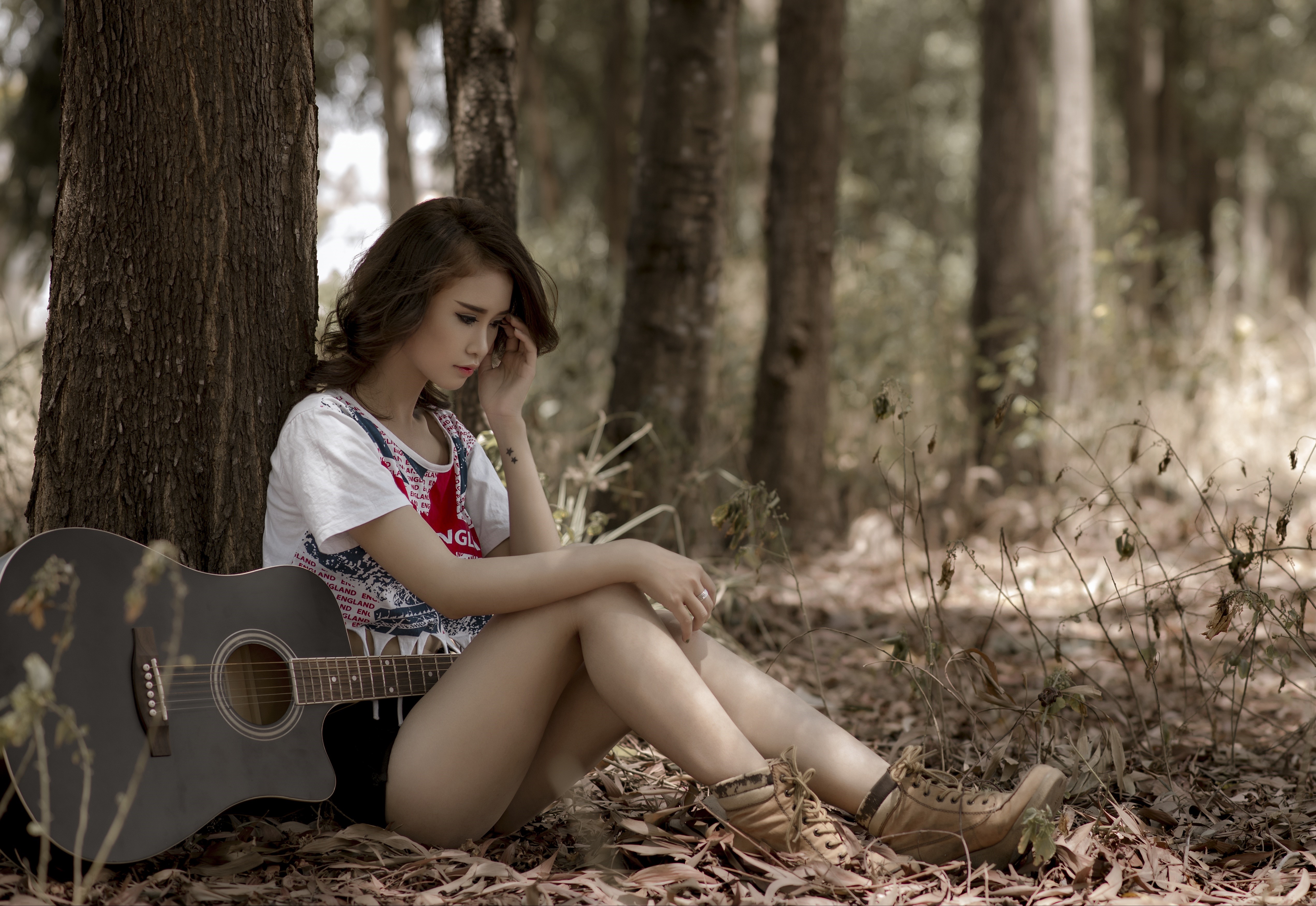 Asian woman with guitar sitting by a tree trunk HD Wallpaper