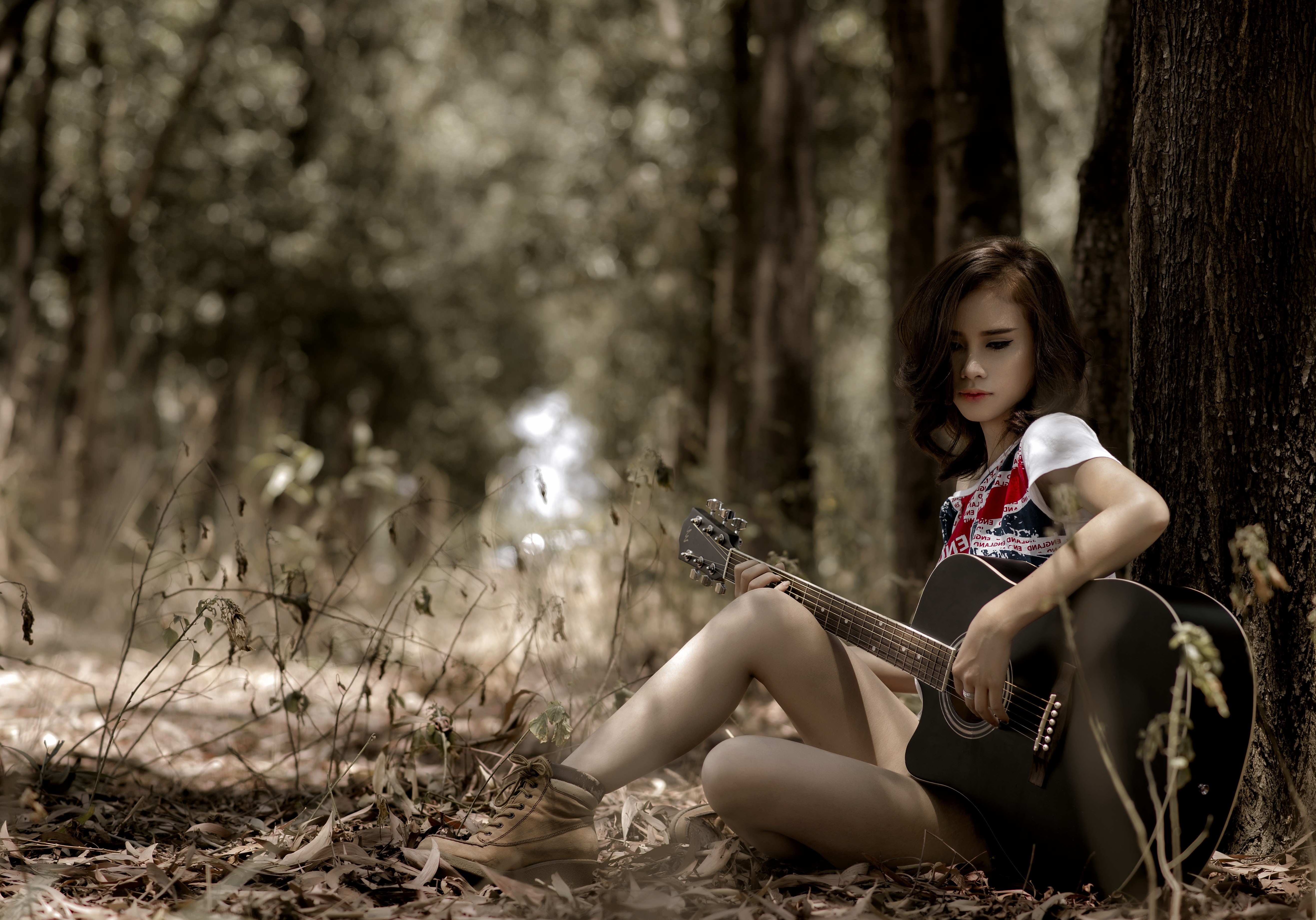 Asian girl playing guitar in forest HD Wallpaper