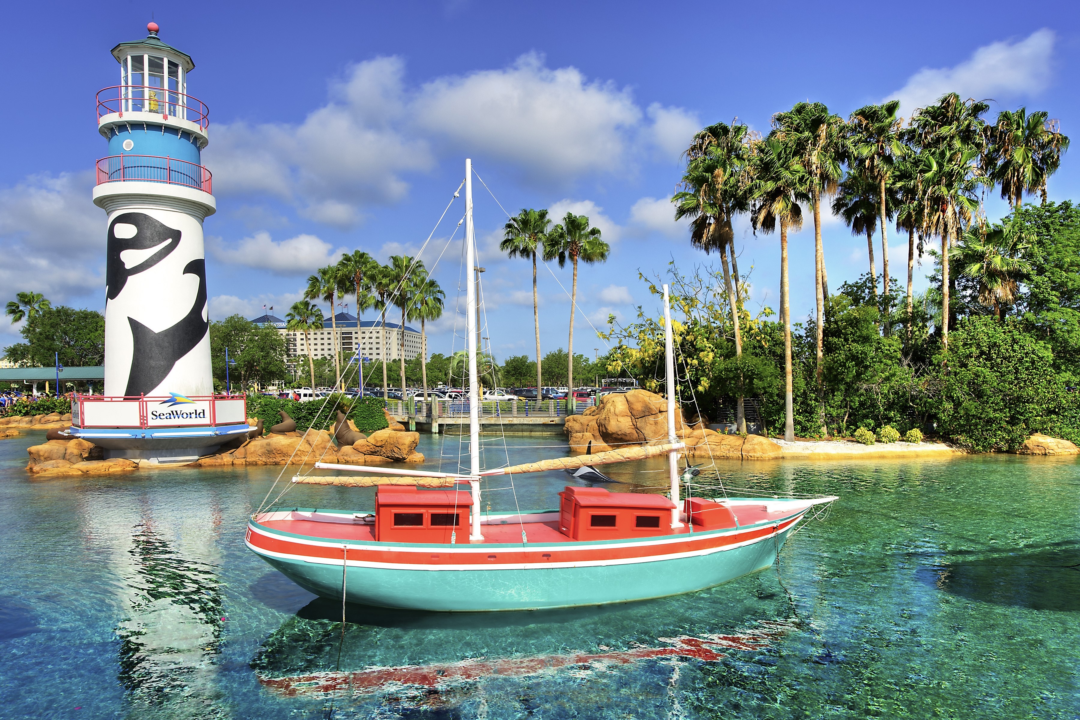 SeaWorld Orlando lighthouse and boat with palm trees HD Wallpaper