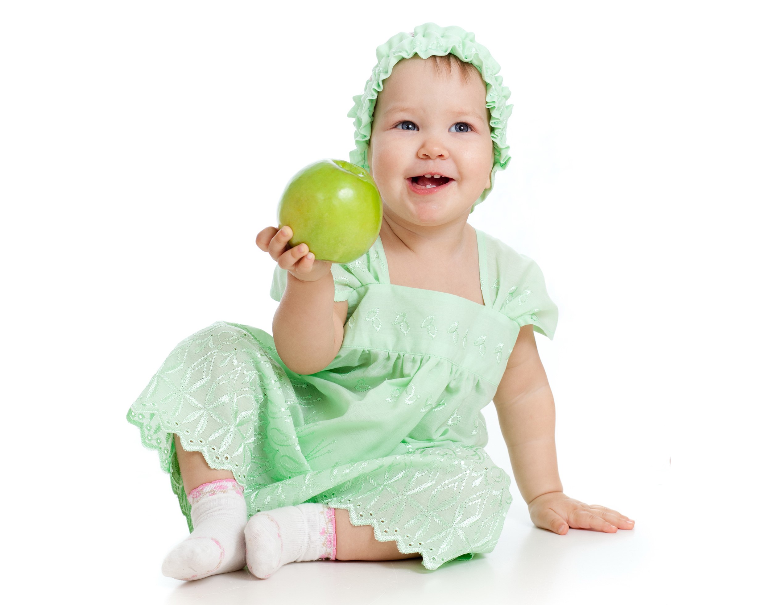 Baby girl in green dress holding an apple HD Wallpaper